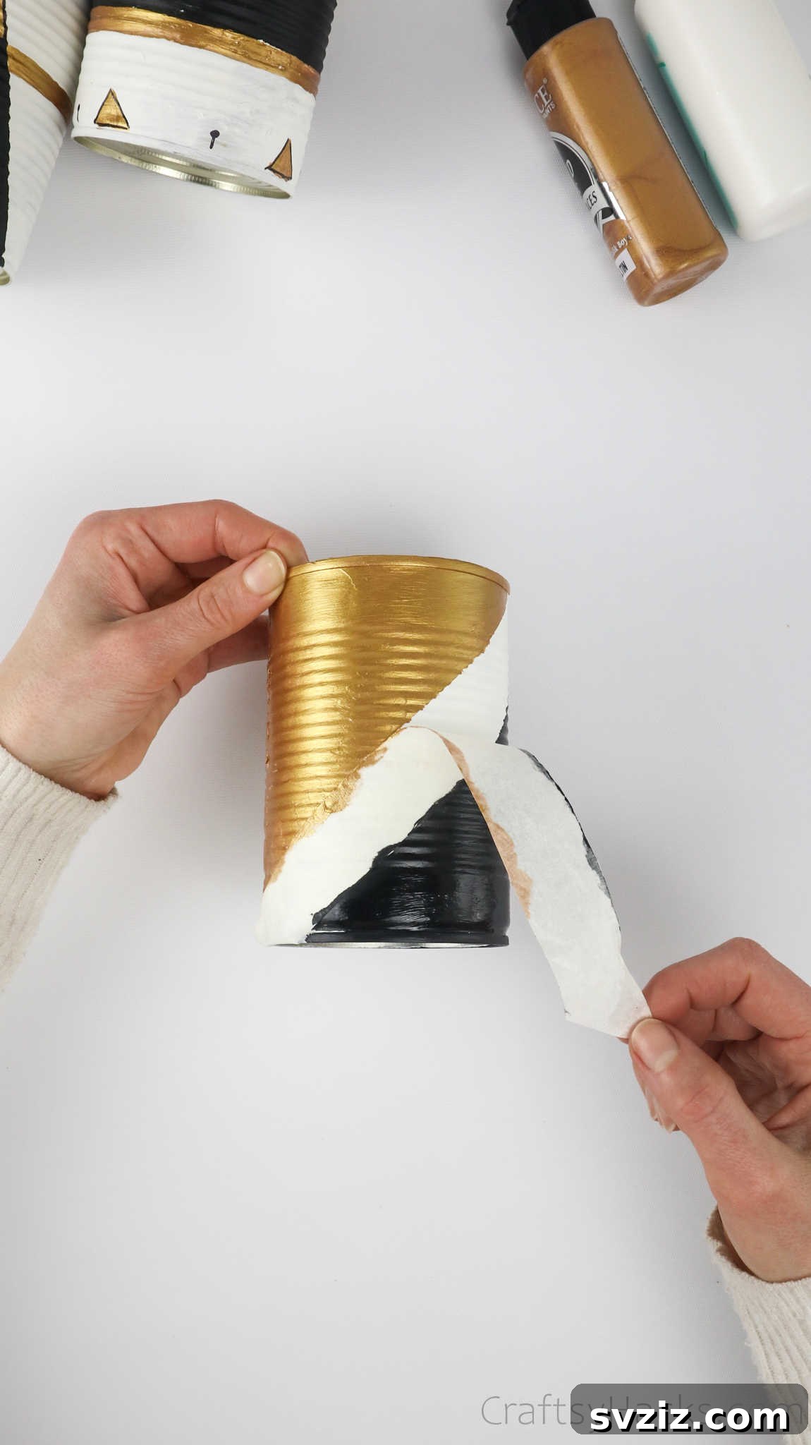 Repurposed Tin Treasures 12 Carefully removing masking tape from a painted tin can to reveal the finished pattern