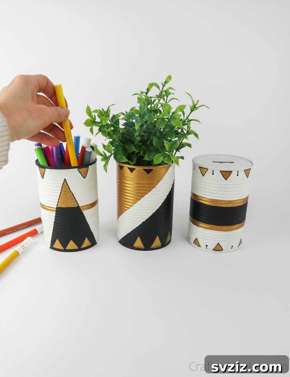 Repurposed Tin Treasures 3 Hand placing a pen into a stylishly painted upcycled tin can, showcasing its utility
