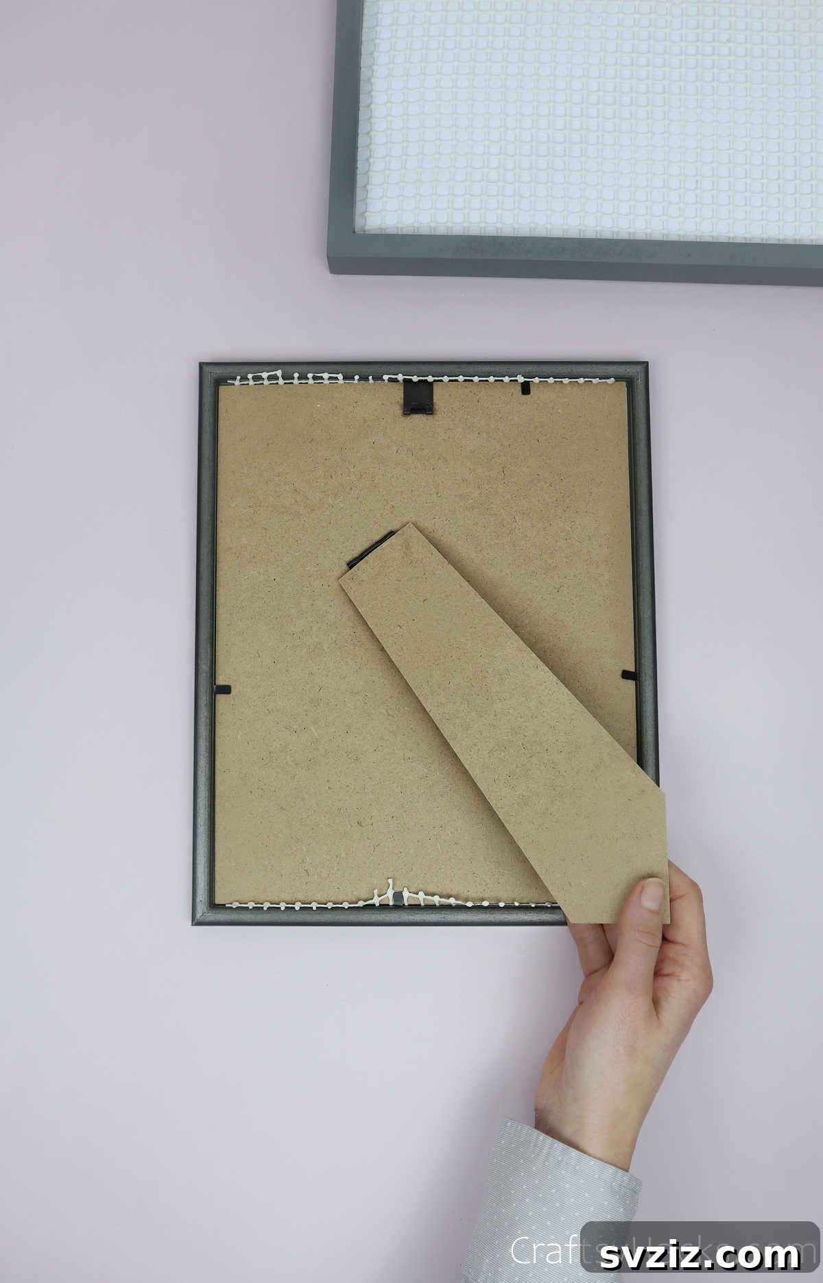 Turn Old Frames into a Chic Earring Organizer 11 Attaching the stand to the back of the DIY earring organizer for tabletop display