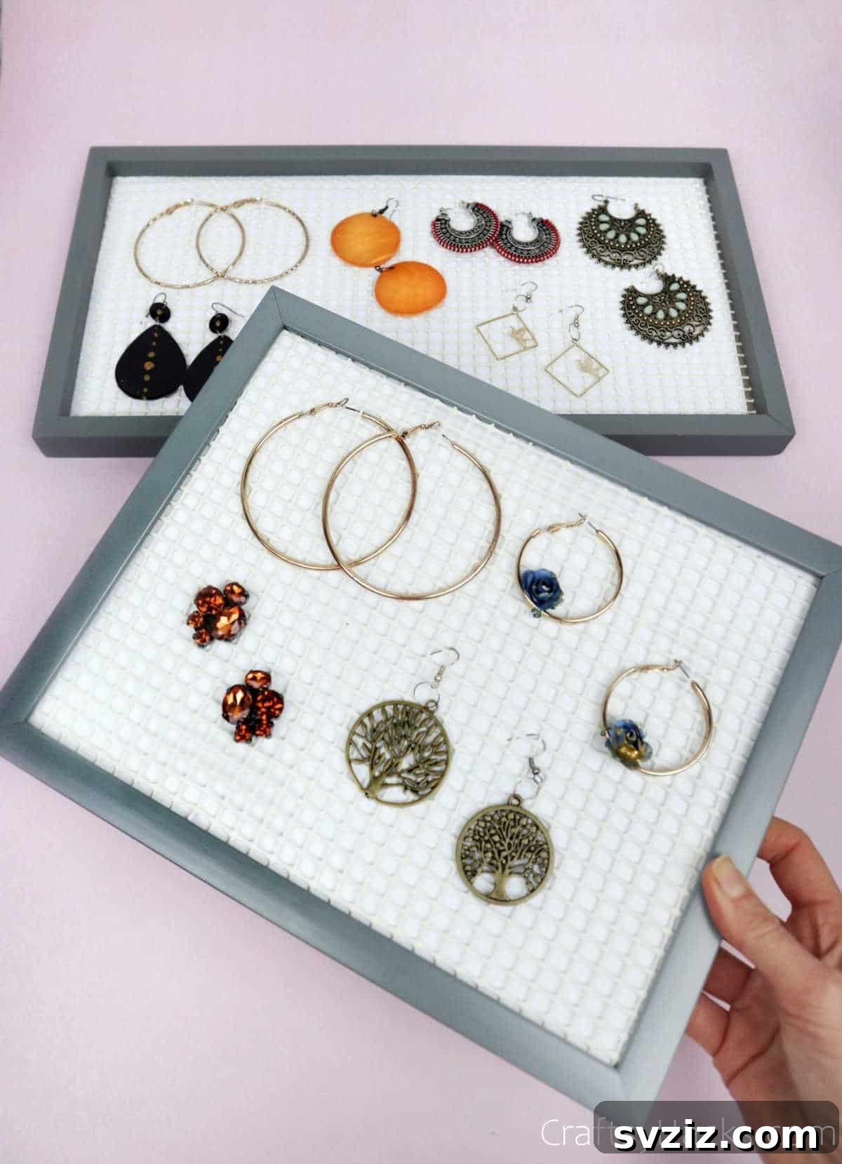 Turn Old Frames into a Chic Earring Organizer 18 A person holding a completed DIY earring organizer, ready for use