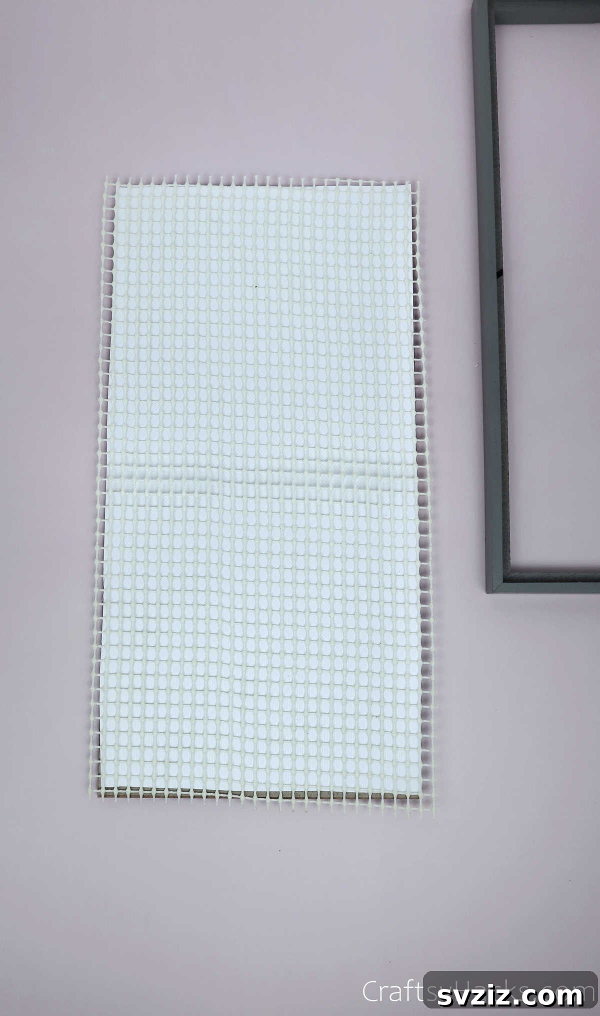 Turn Old Frames into a Chic Earring Organizer 8 Placing the cut shelf liner onto the backdrop paper within the photo frame