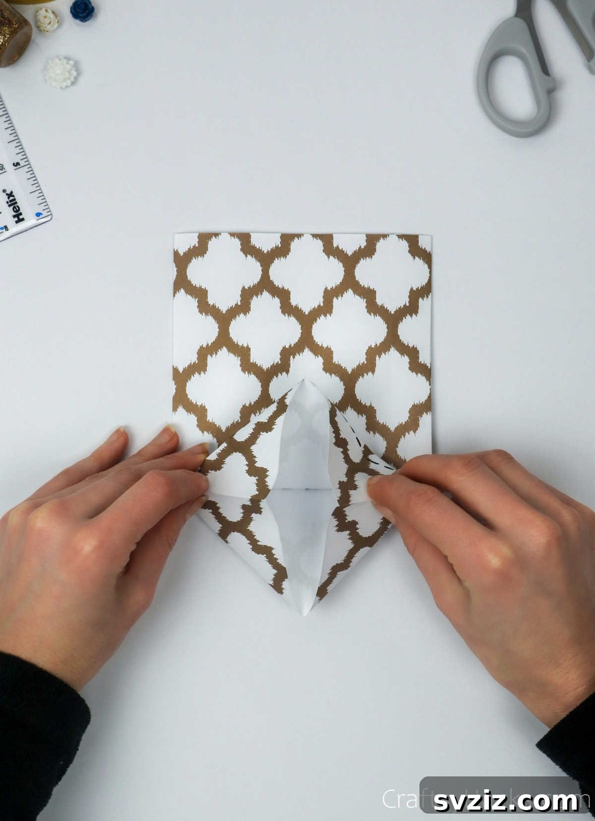 Homemade Touch: Custom Gift Bags 16 Hands carefully folding the paper inward to form a square base for the gift bag.