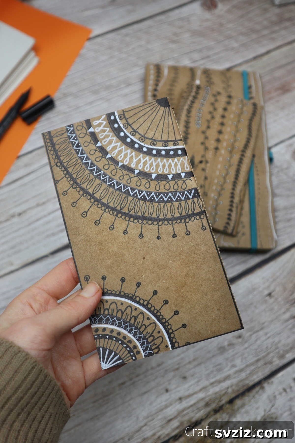 Make Your Journal Cover Unique 2 A person holding a beautifully decorated DIY journal cover, showcasing intricate designs and vibrant colors.
