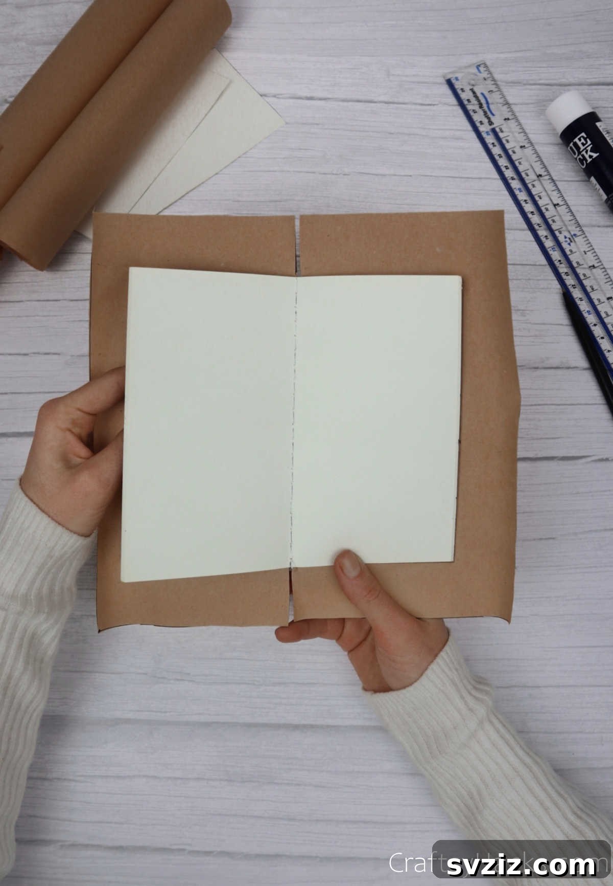 Make Your Journal Cover Unique 13 A piece of kraft paper, now attached to a notebook, with a vertical cut made from the bottom edge up to the notebook's cover.