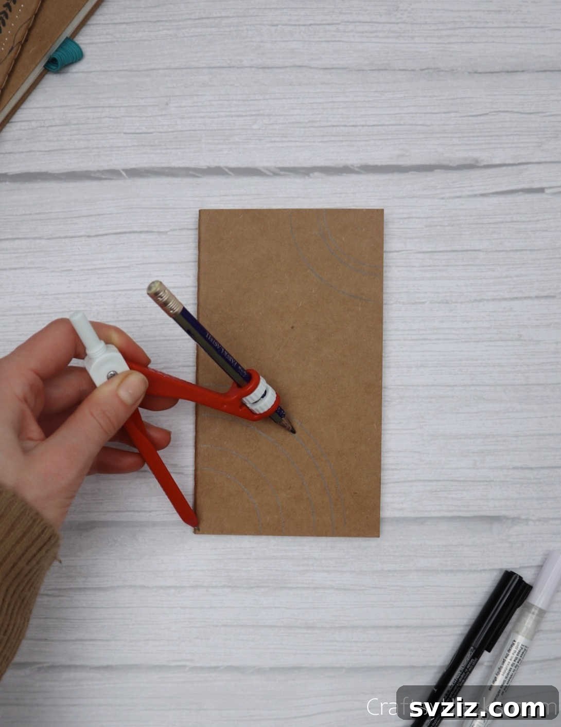 Make Your Journal Cover Unique 21 A close-up of a hand using a pencil and ruler to draw geometric patterns on the journal cover, preparing for intricate designs.