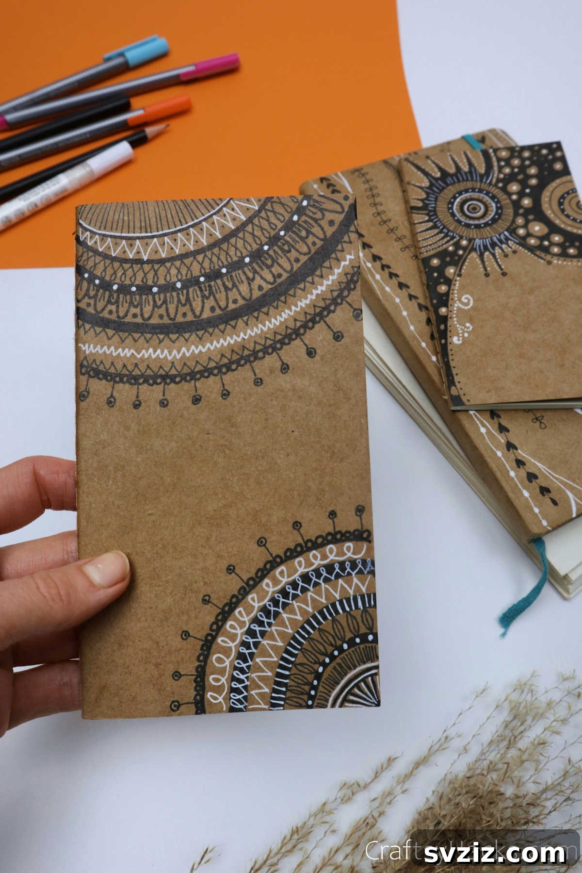 Make Your Journal Cover Unique 23 A beautifully completed DIY journal cover featuring an intricate black and white mandala and zentangle design.