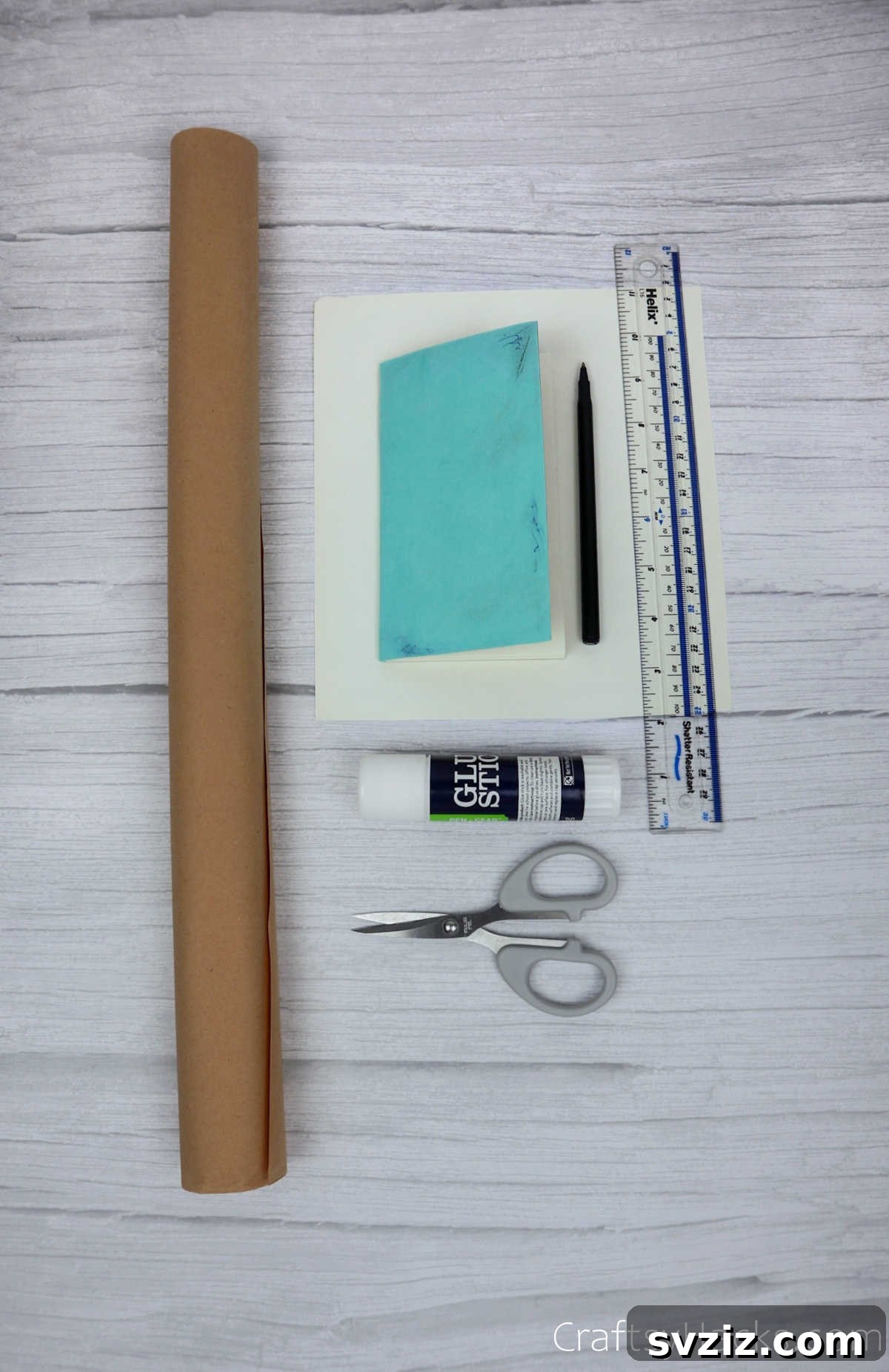 Make Your Journal Cover Unique 4 A collection of craft supplies including kraft paper, scissors, glue stick, ruler, and pens, neatly arranged.