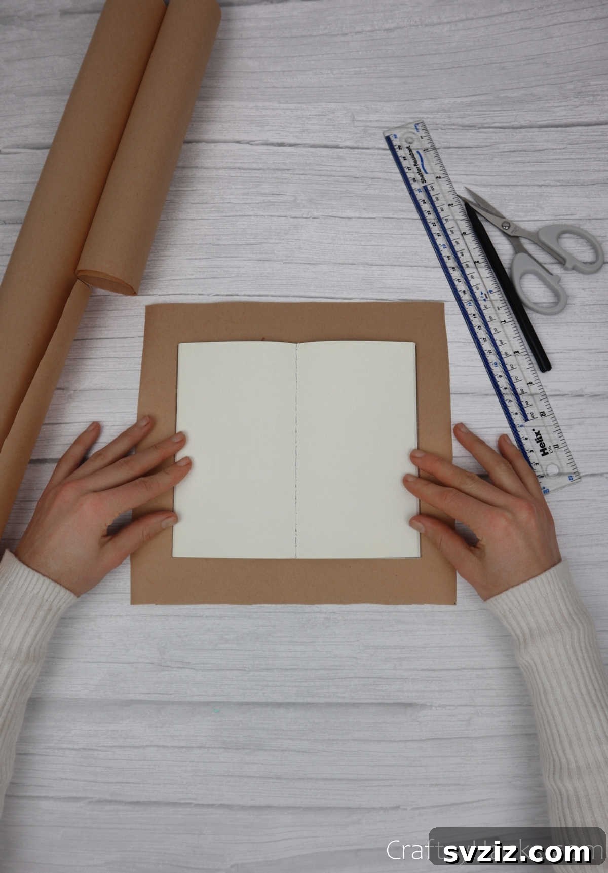 Make Your Journal Cover Unique 6 An open journal resting perfectly centered on a larger piece of cut kraft paper, ready for the next step.