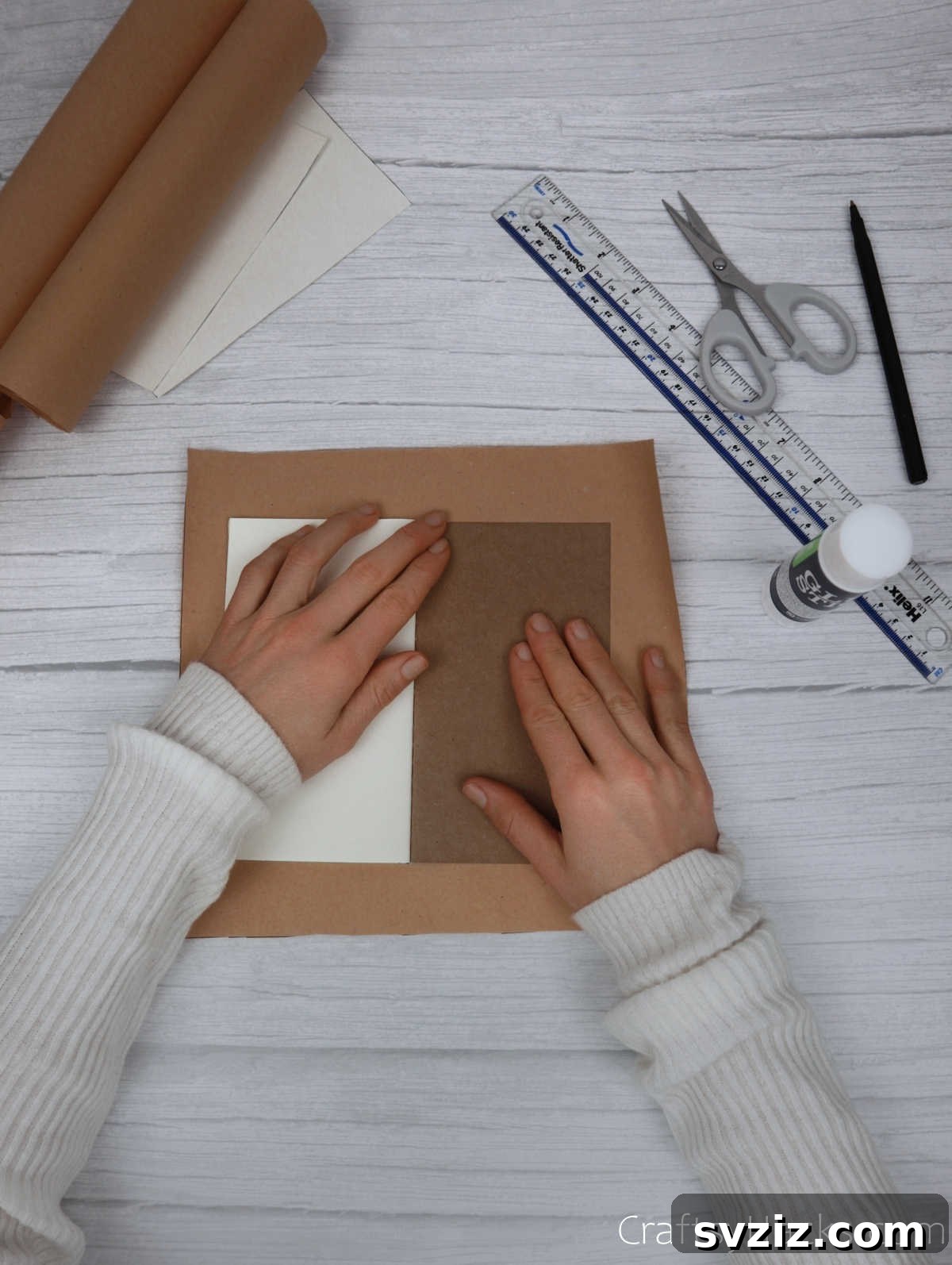 Make Your Journal Cover Unique 10 A notebook pressed firmly onto the center of a large piece of kraft paper, adhering the two together.