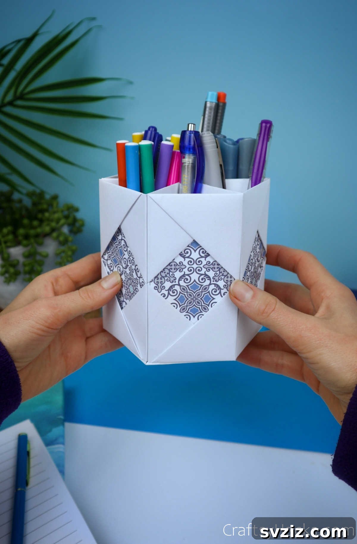Hand holding a beautifully crafted DIY paper pencil holder, showcasing its elegant design and multi-compartment structure.