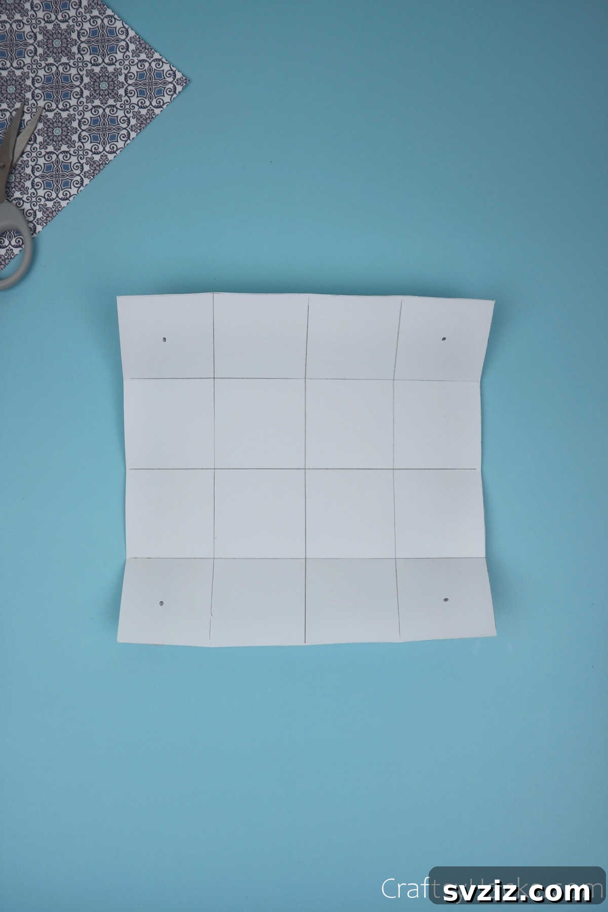 An unfolded paper sheet displaying a perfectly symmetrical 4x4 grid, consisting of 16 equal squares, providing a clear guide for the next folding steps.