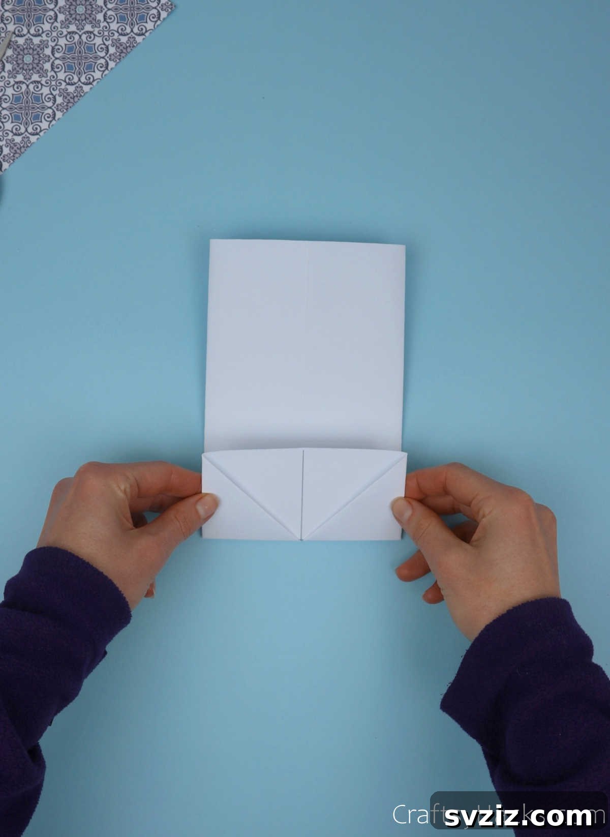 The paper module, now flipped, with its bottom edge being folded upwards by precisely one grid square width.