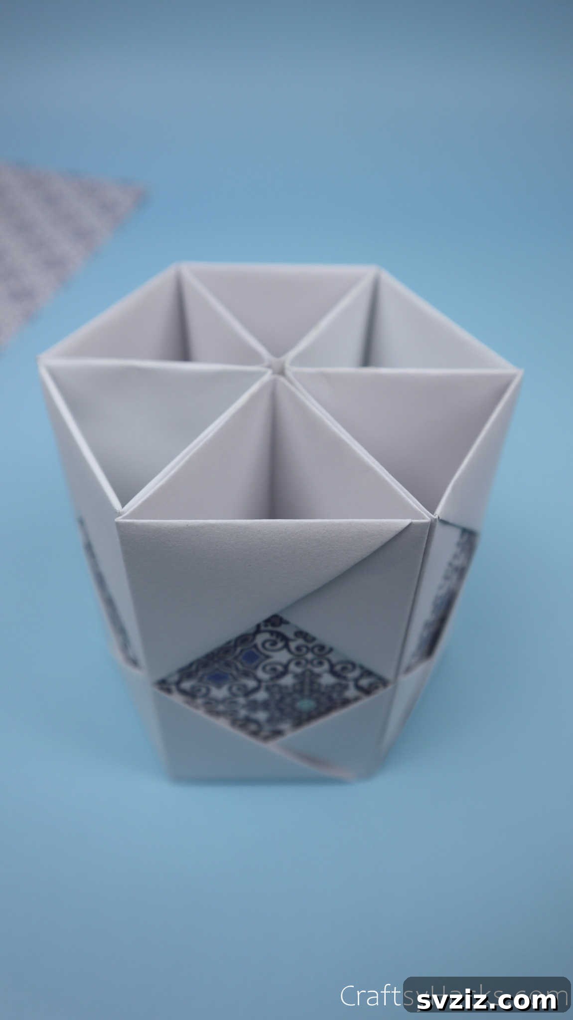The fully assembled hexagonal paper pencil holder body, standing upright on a surface, showcasing its completed form before the base is attached.