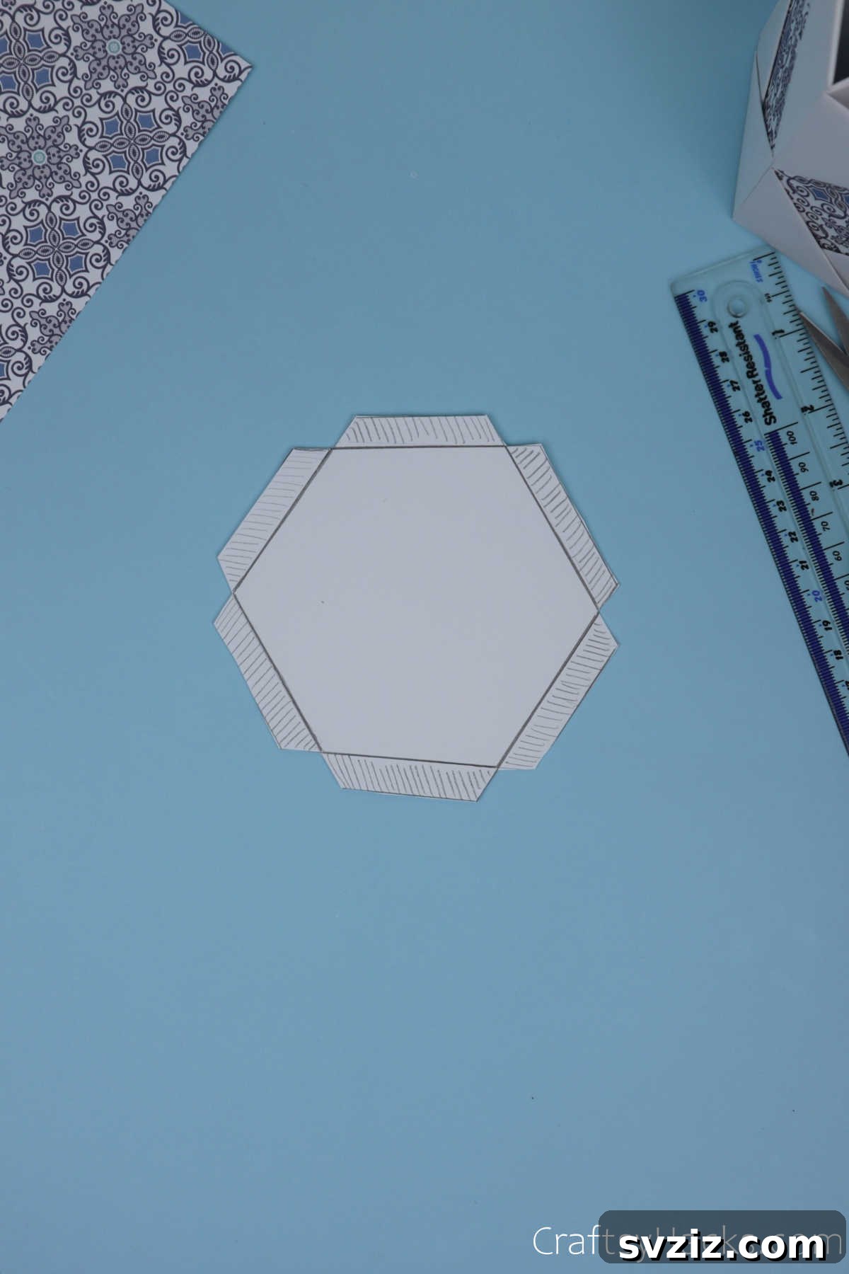 The precisely cut hexagonal base with its perimeter flaps already separated from the thick paper, ready for folding.