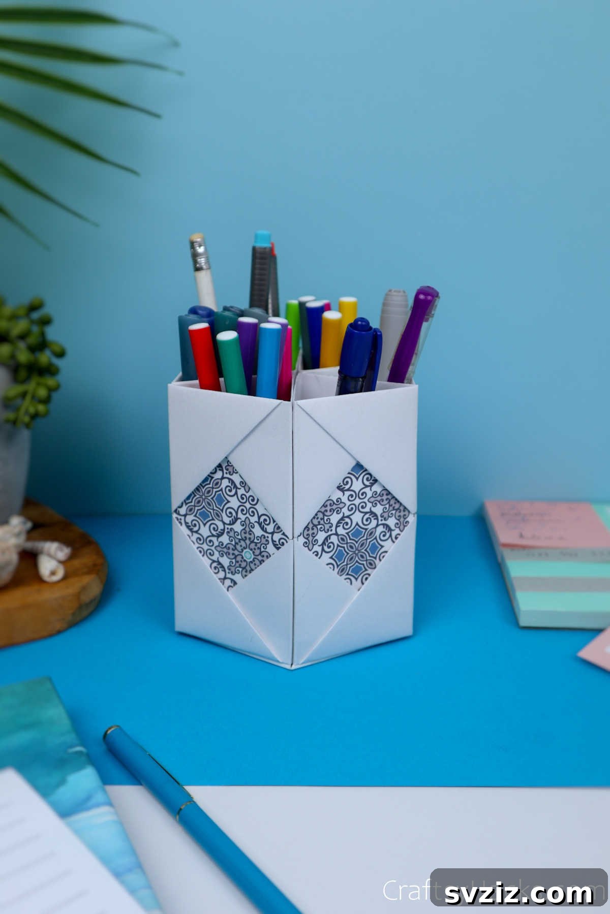 The elegant DIY paper pencil holder standing on a desk alongside other stationery, showcasing its practical functionality and aesthetic integration into a workspace.
