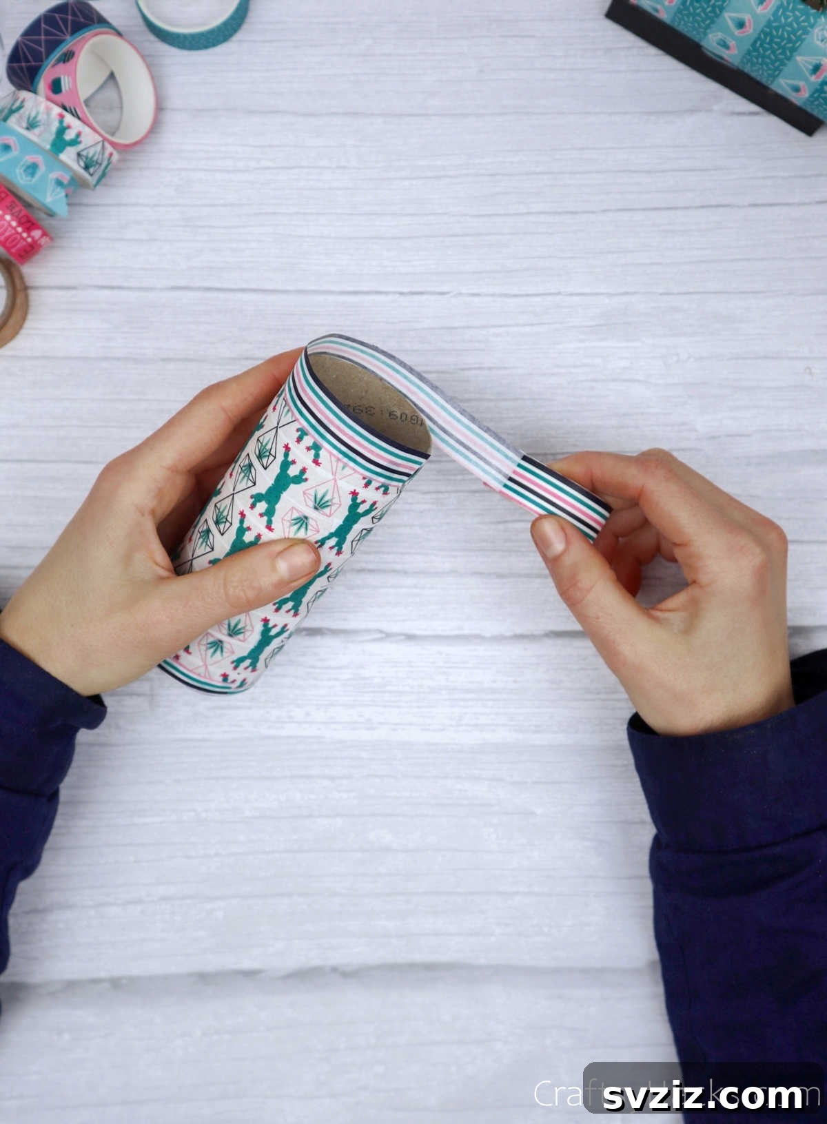 Roll Your Own Phone Stand from a Toilet Paper Tube 11 A close-up of washi tape being wrapped around the edge of a toilet paper roll, with tape extending beyond the rim.