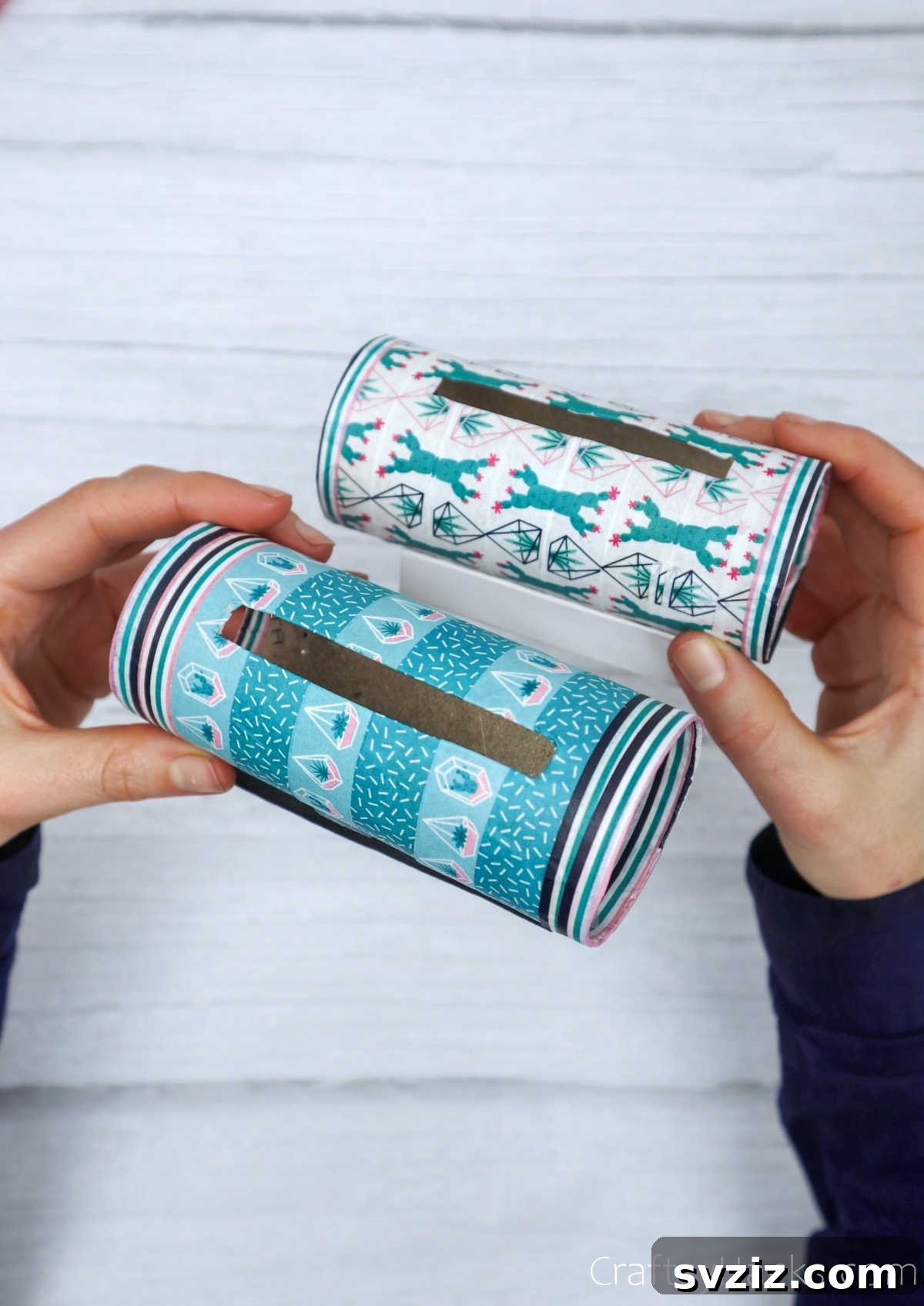 Roll Your Own Phone Stand from a Toilet Paper Tube 4 A hand presenting two finished DIY phone holders, demonstrating their compact and stylish design.