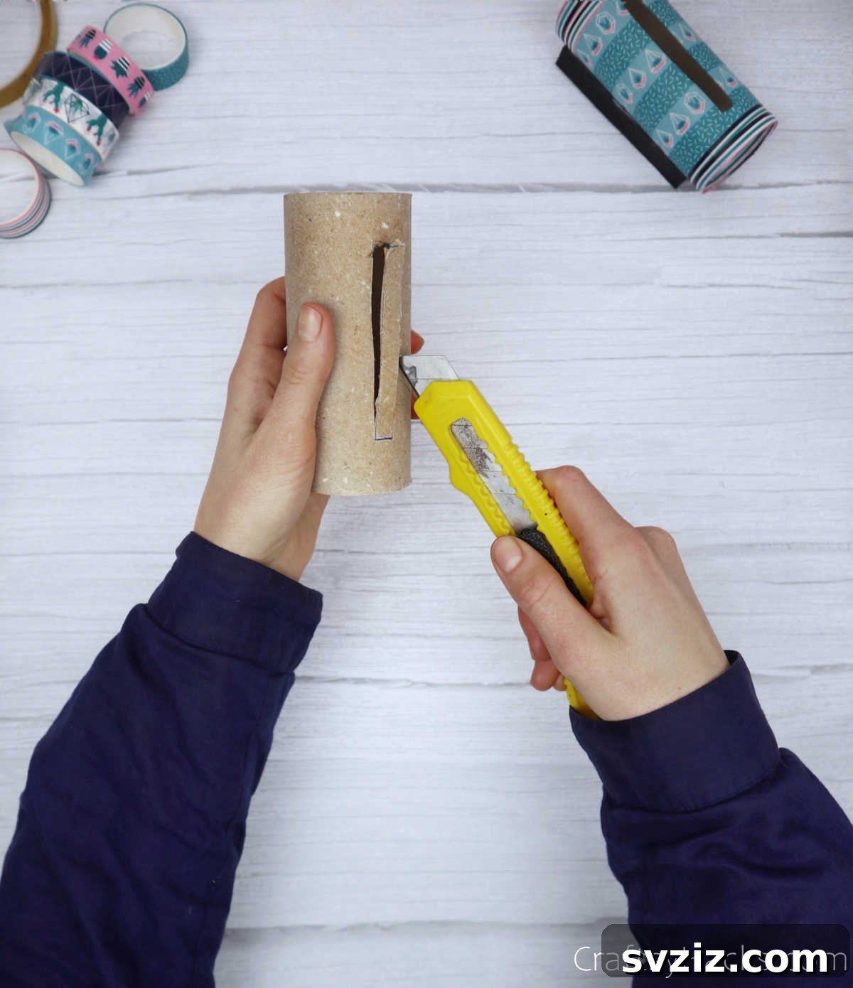 Roll Your Own Phone Stand from a Toilet Paper Tube 7 A craft cutter being used to carefully cut a rectangular slot into a toilet paper roll.