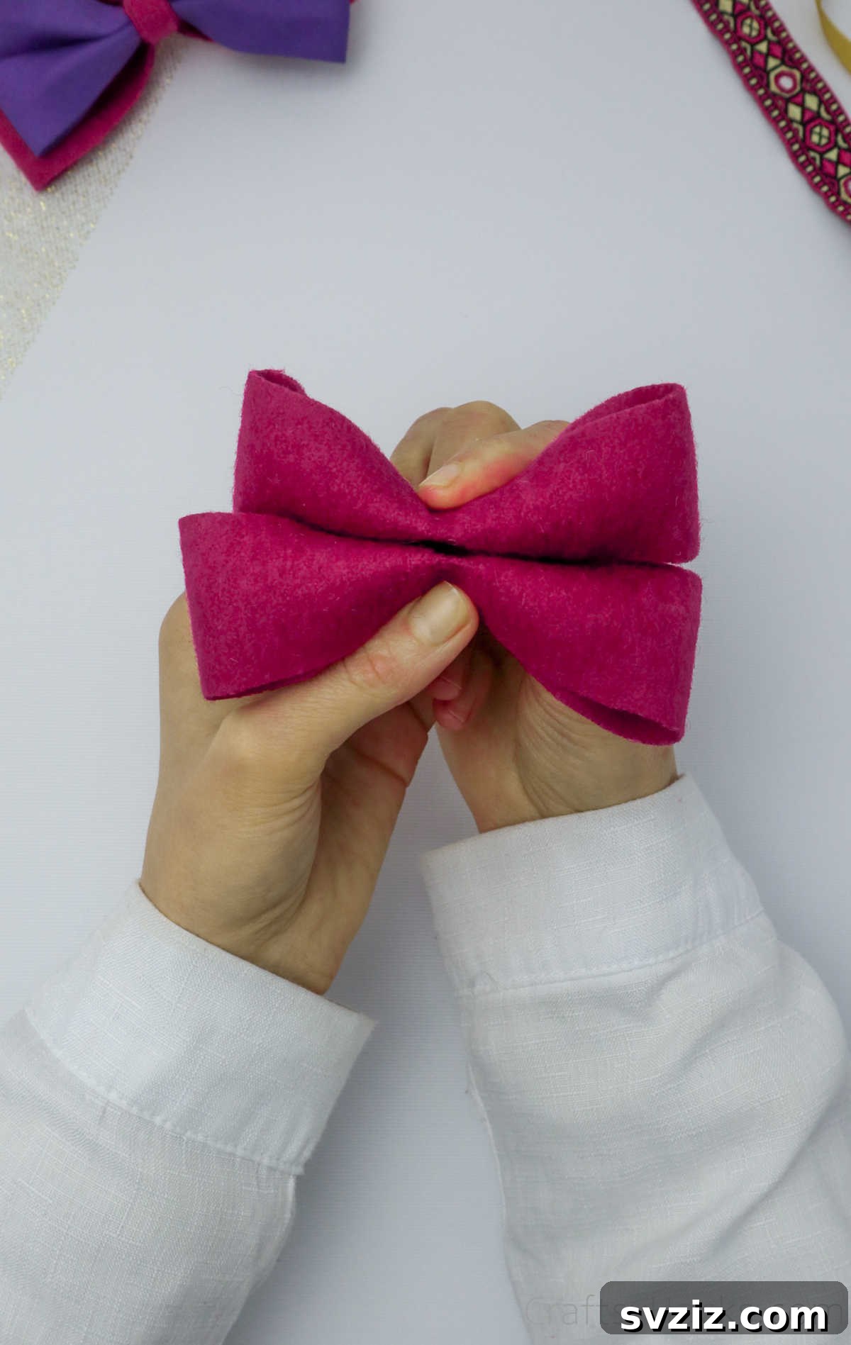 Two distinct pink felt bows held together, demonstrating their positioning before being glued as a layered hair accessory
