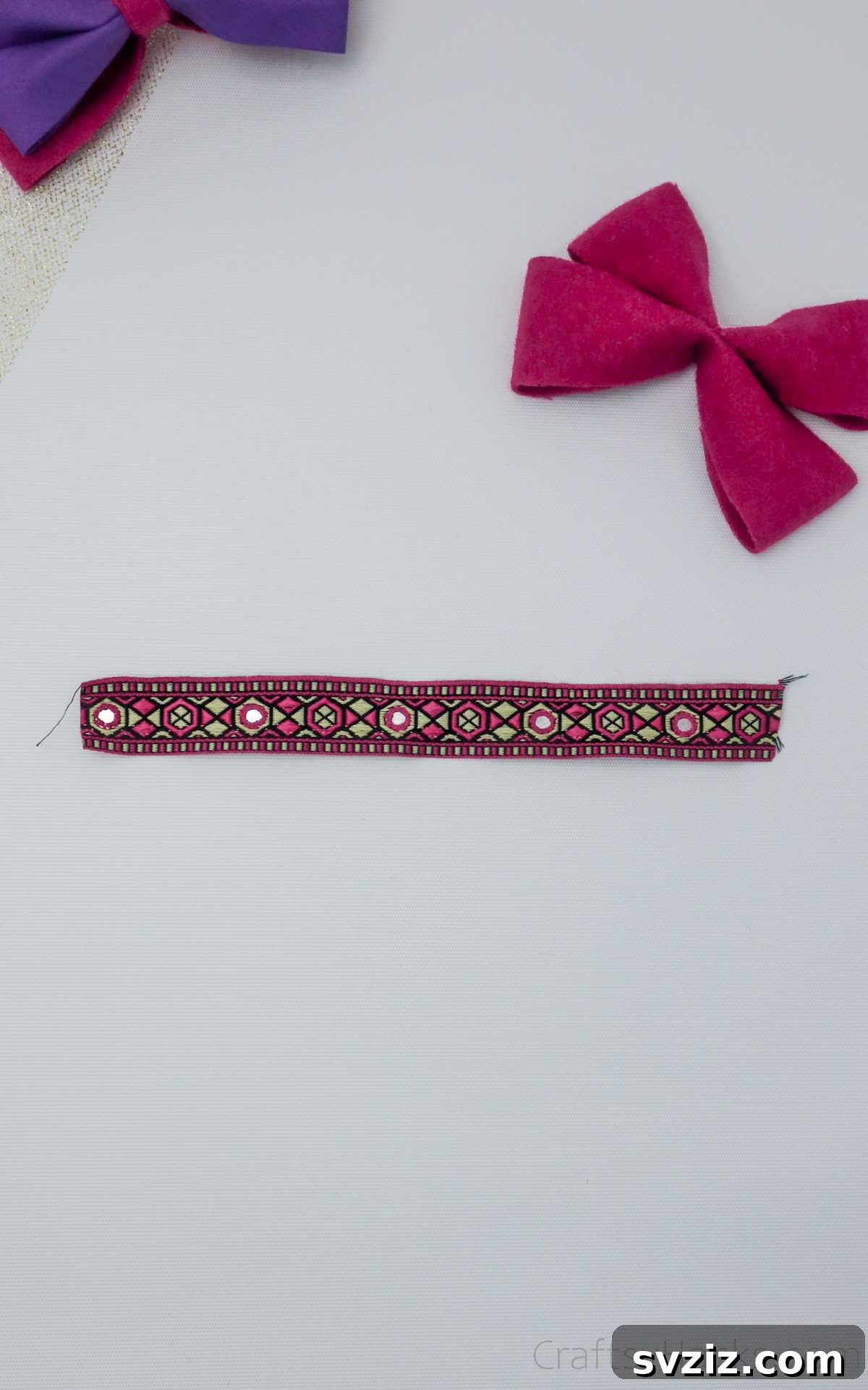A precisely cut and folded piece of ribbon, ready to be attached as the decorative center of the hair bow