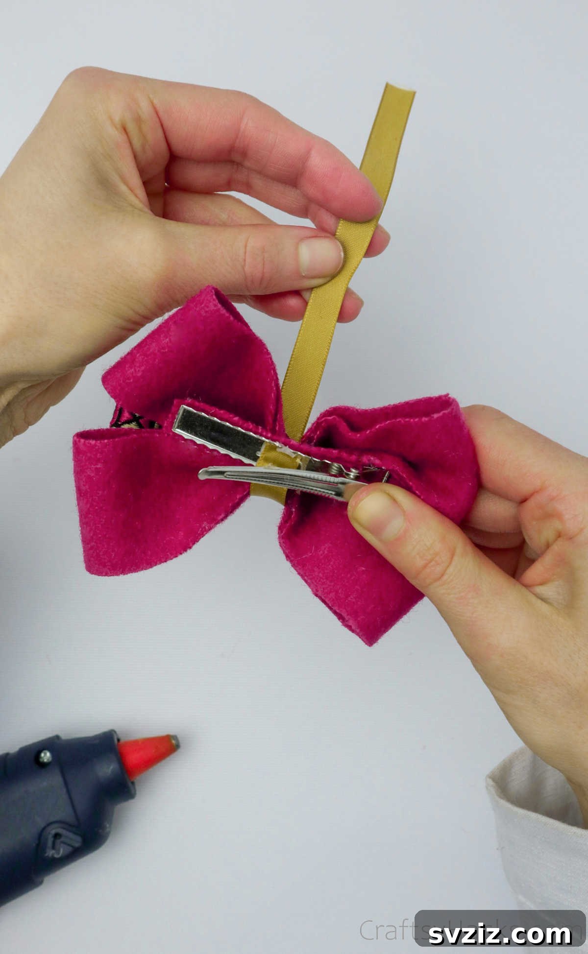 The yellow ribbon being meticulously wrapped around the center of the bow, creating a decorative and functional tie