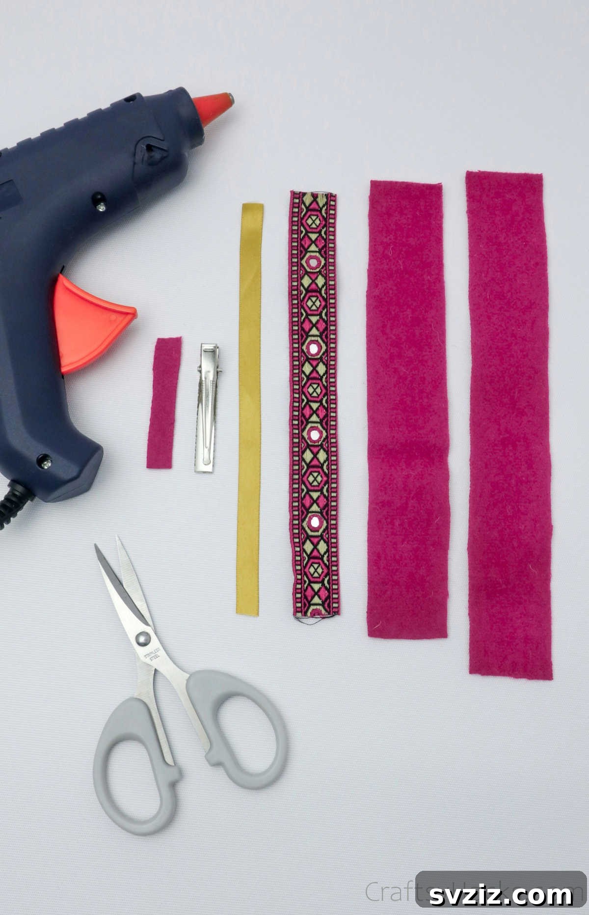 Arrangement of various craft supplies including felt strips, ribbons, and a glue gun, essential for making DIY hair bows