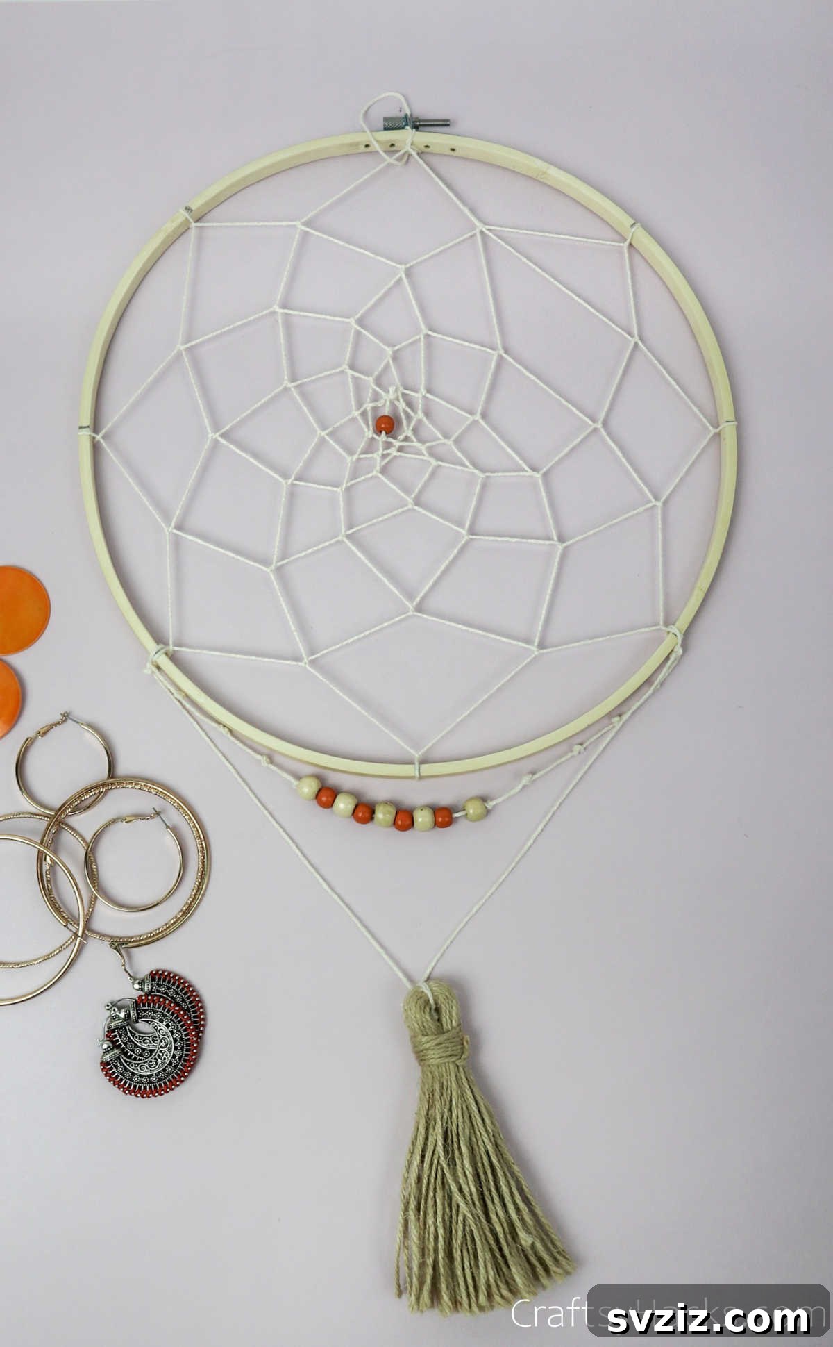 From Clutter to Charm: DIY Jewelry Storage 34 A close-up of a finished DIY dreamcatcher jewelry organizer, highlighting the intricate white string pattern and the central bead, showcasing the craftsmanship.