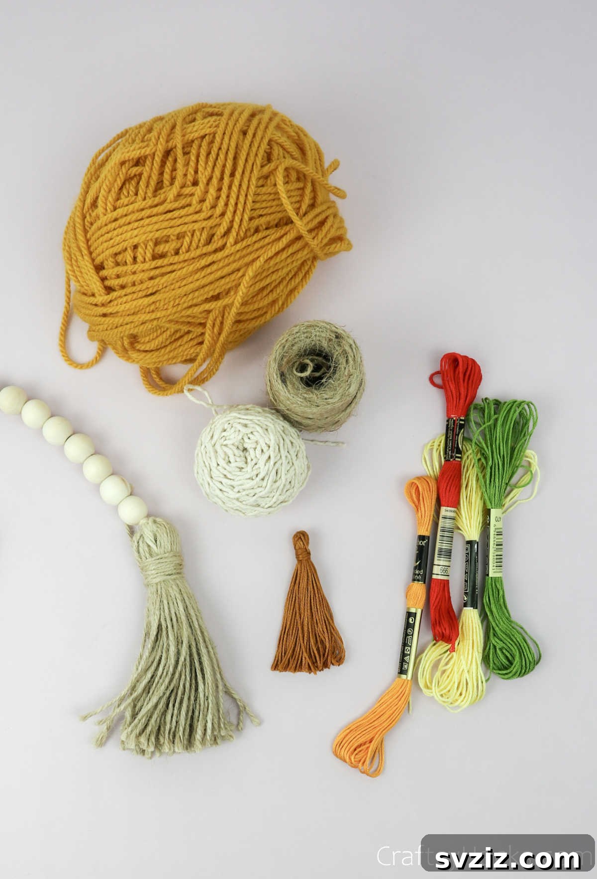 From Clutter to Charm: DIY Jewelry Storage 6 Close-up of a spool of beige cotton string and a larger roll of matching yarn, showcasing their texture, laid out on a clean white surface as part of the craft supplies.