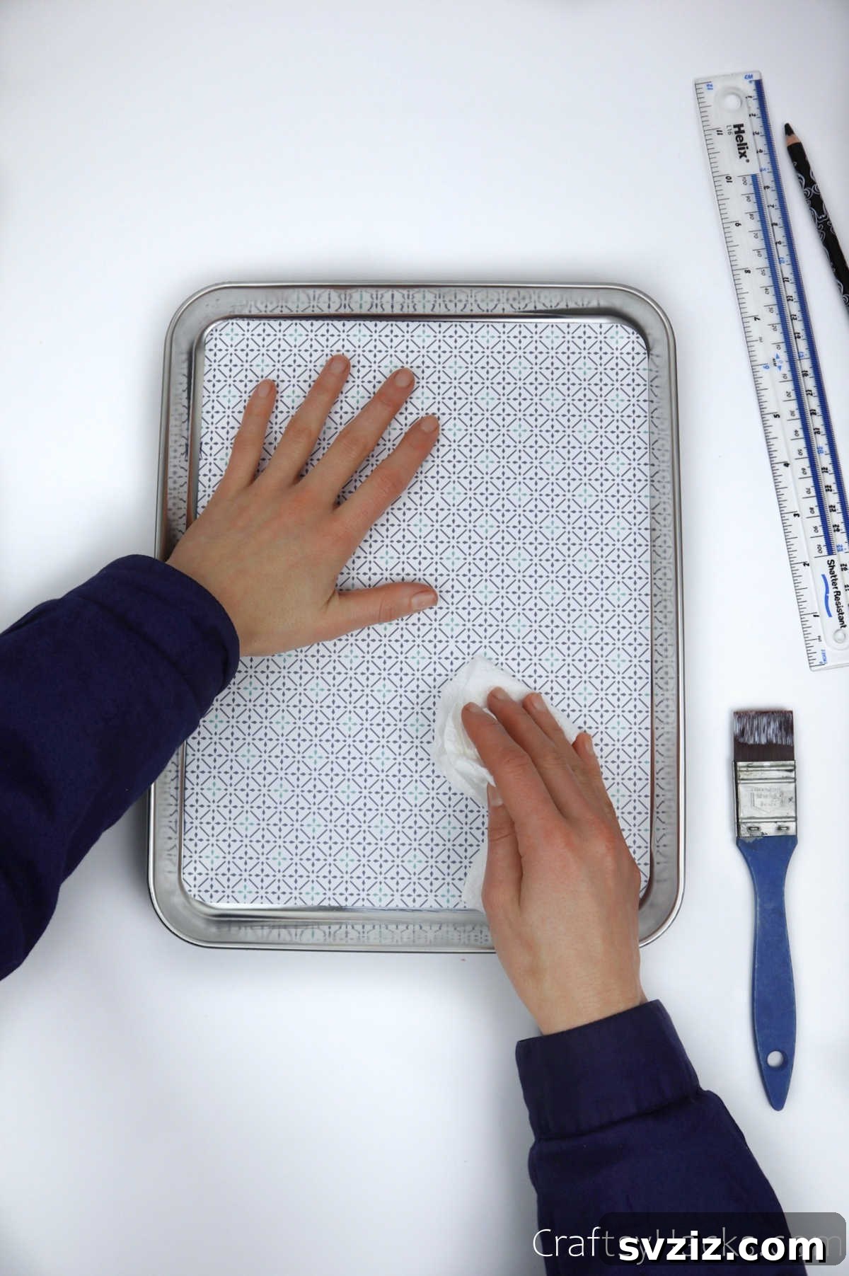 Smoothing out decorative paper on a tray