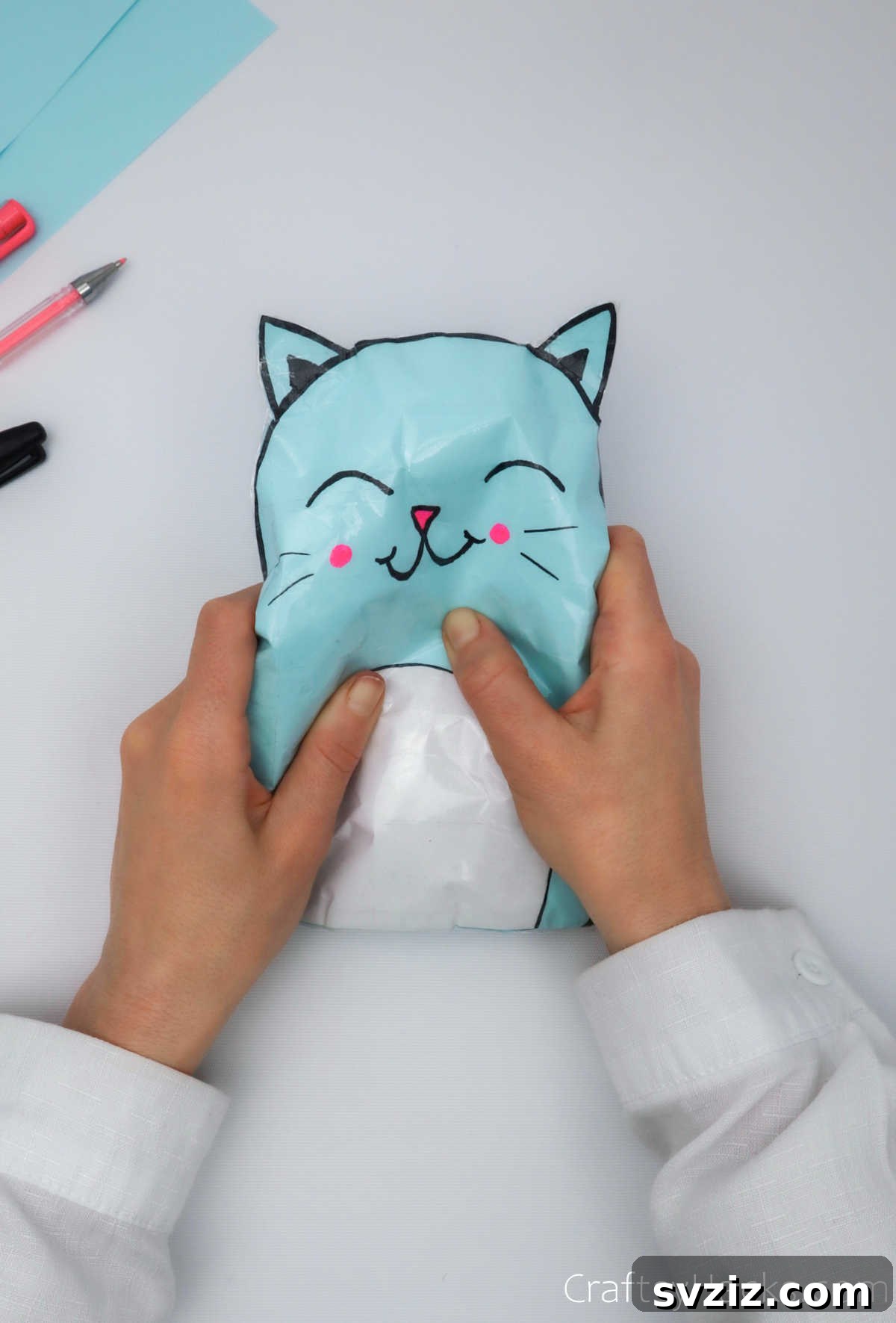 Create Adorable Paper Squishies Print Play 9 Child happily squishing a completed paper cat squishy.
