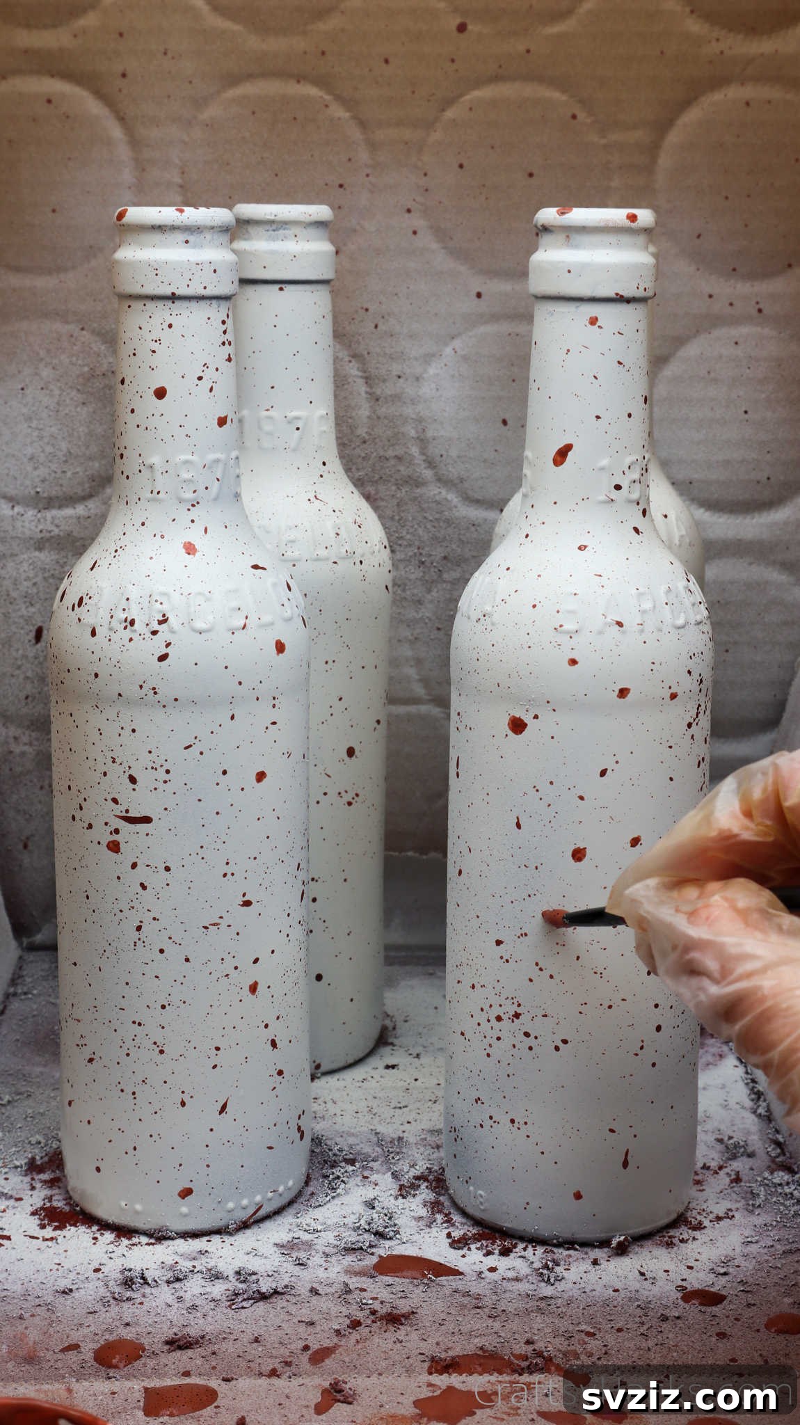 Painting dots on white beer bottles for custom design