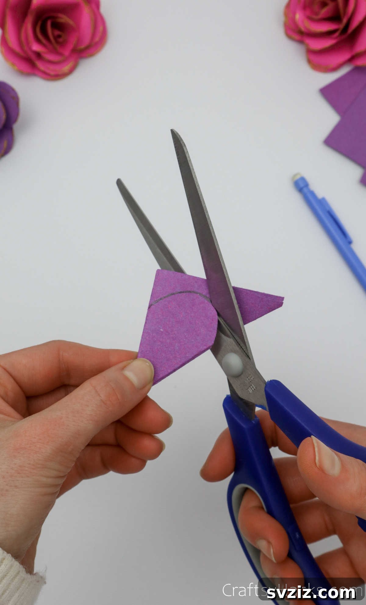 Crafting Beautiful Paper Blooms 11 Scissors carefully cutting along the drawn arc on the folded paper to form a petal