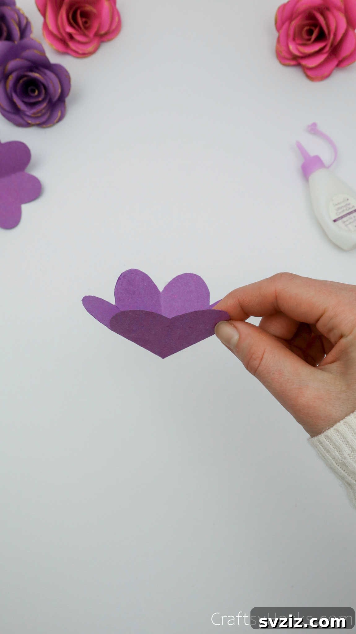 Crafting Beautiful Paper Blooms 19 A hand holding a single, completed paper flower layer with a curved form