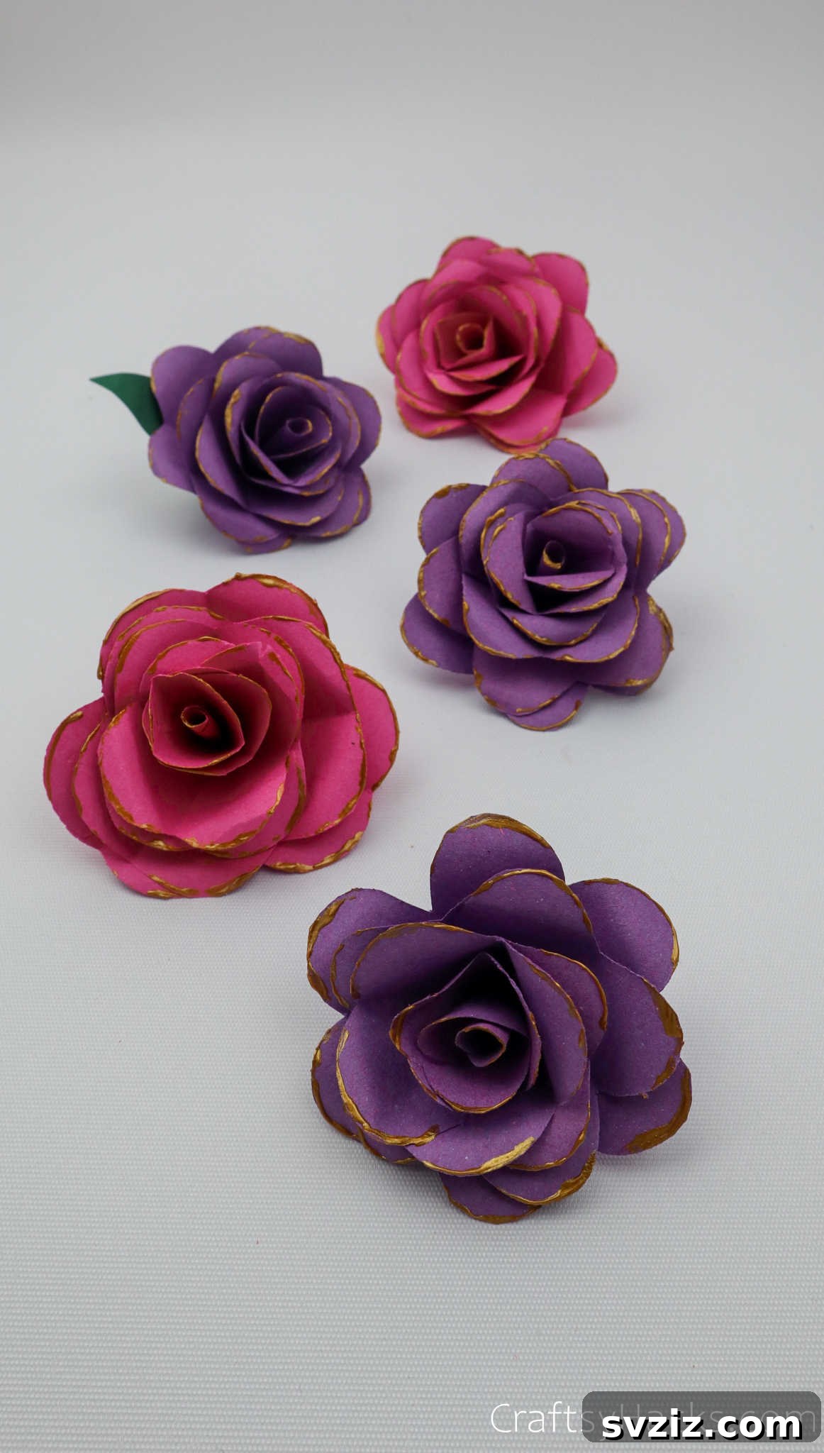 Crafting Beautiful Paper Blooms 31 A collection of five finished paper flowers in varying shades of purple, neatly arranged