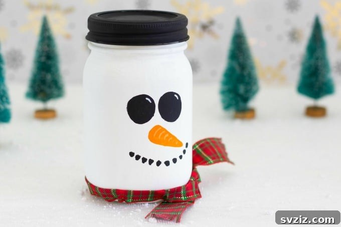 Mason jar painted and decorated as a snowman.