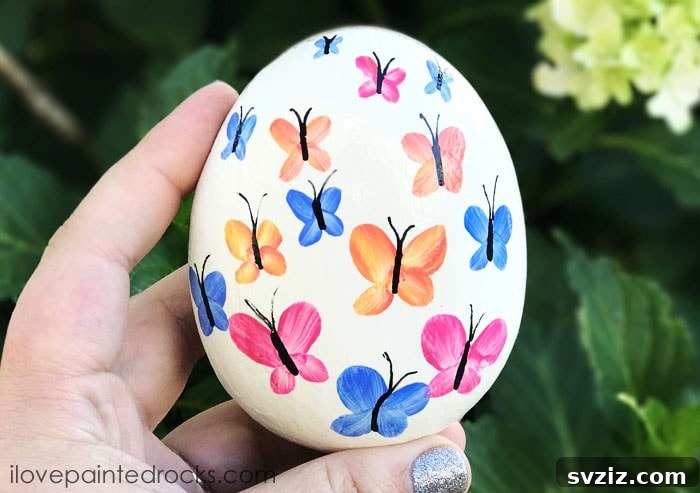 Tiny Treasures: 41 Adorable Rock Painting Ideas 21 Exquisite Butterfly Rock, painted with delicate watercolor effects.