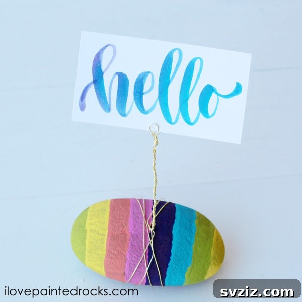 Tiny Treasures: 41 Adorable Rock Painting Ideas 27 Vibrant Rainbow Striped Rock Photo Holder, a colorful way to display photos.
