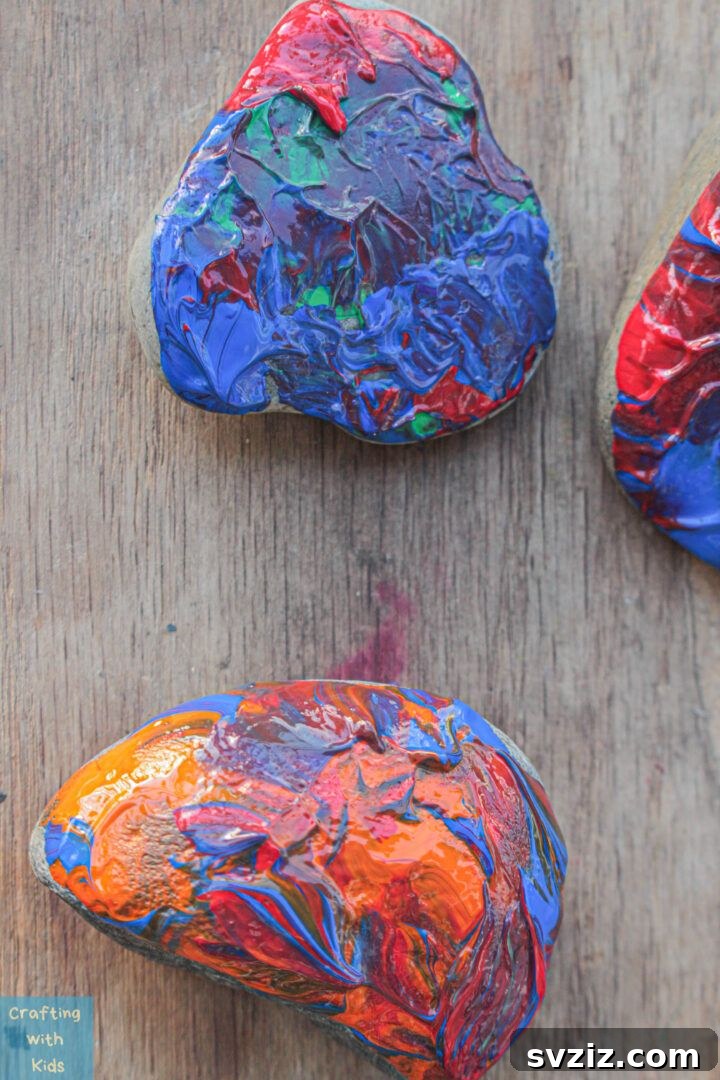 Tiny Treasures: 41 Adorable Rock Painting Ideas 37 Mesmerizing Rock Dip Painting with swirling acrylics, creating unique patterns.