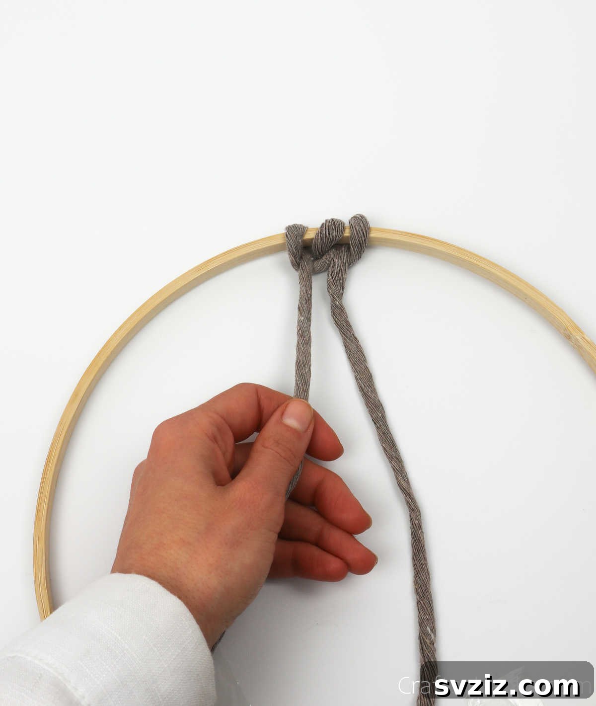 A completed two-part knot with the left string securely fastened on the hoop.