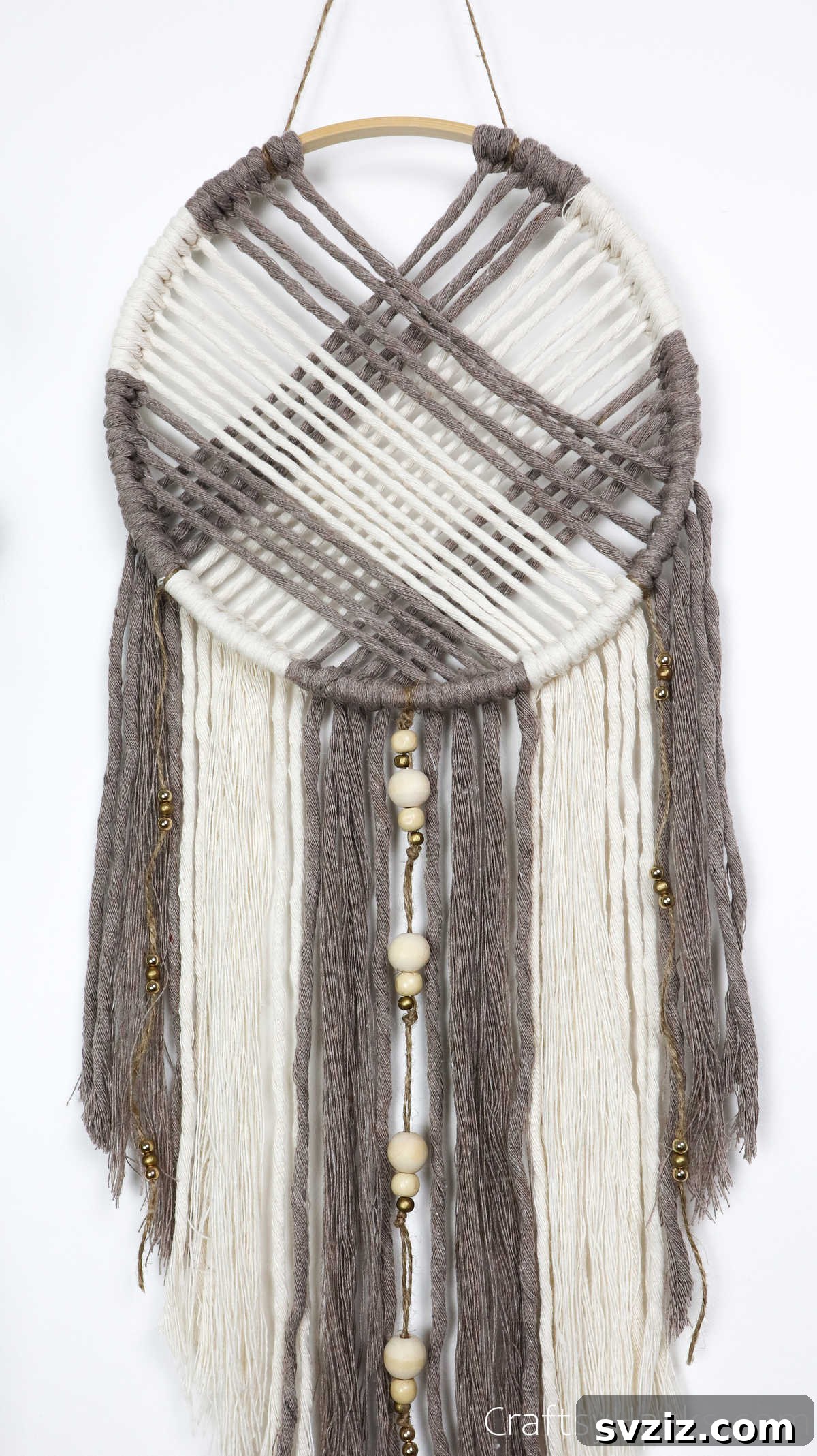 A close-up of a handmade DIY dreamcatcher, showcasing its intricate web and delicate hanging elements.