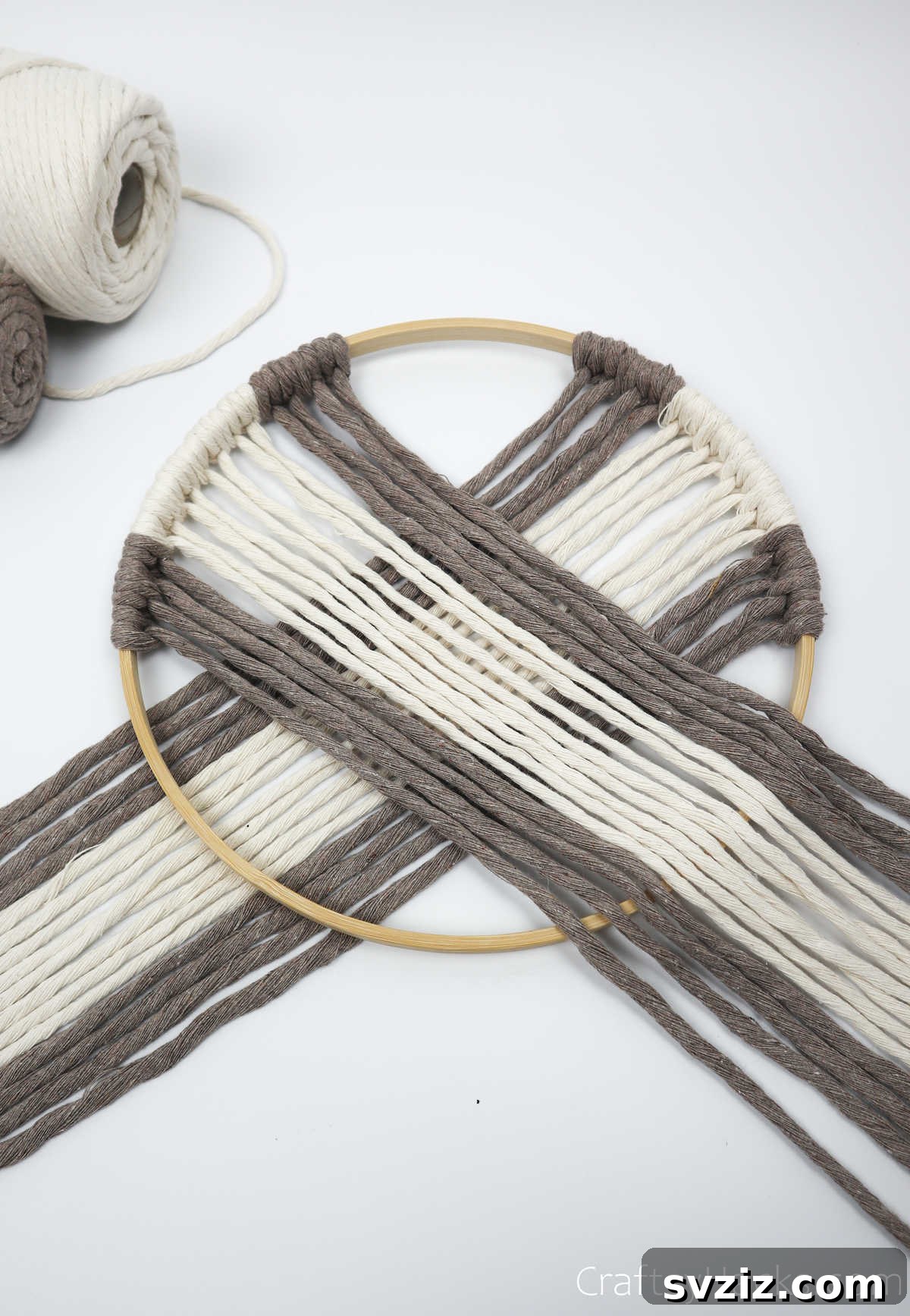 Close-up of the yarn crossing from both sides of the hoop, forming the central design of the dreamcatcher.