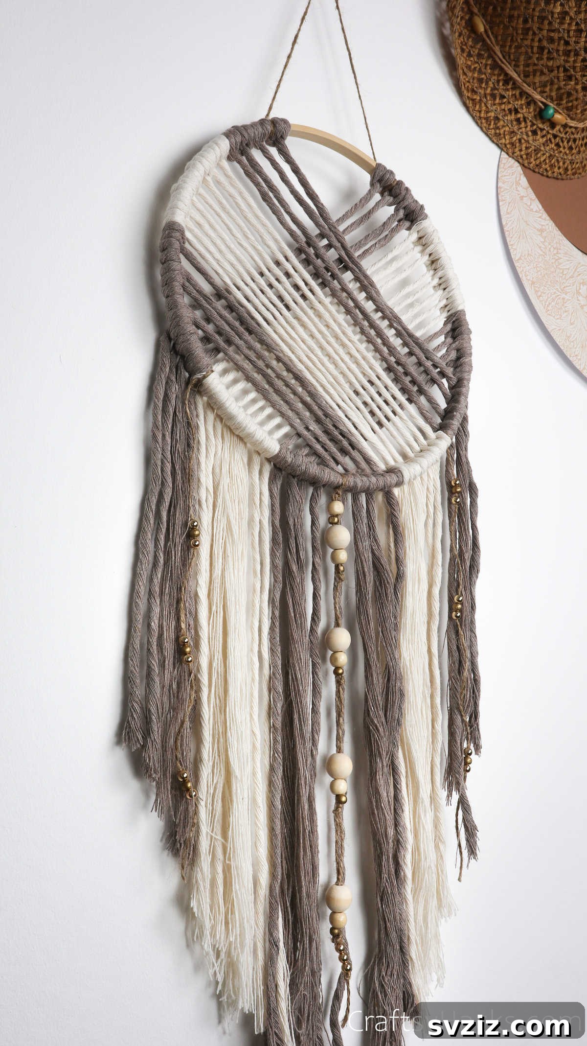 An elegantly designed dreamcatcher with various strands and adornments, ready to be hung.