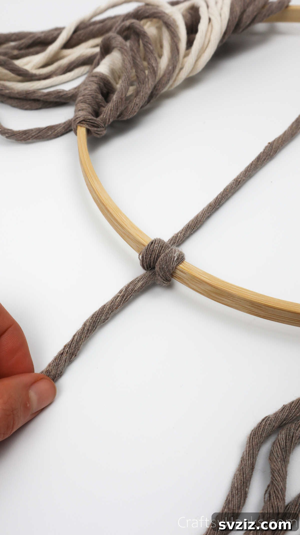 A completed, secure two-part knot tying the diagonal yarn to the hoop.