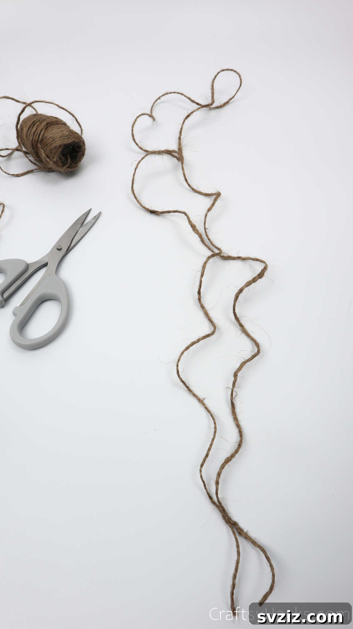A length of jute twine with beads strung on it, secured by knots, ready to be added to the dreamcatcher.