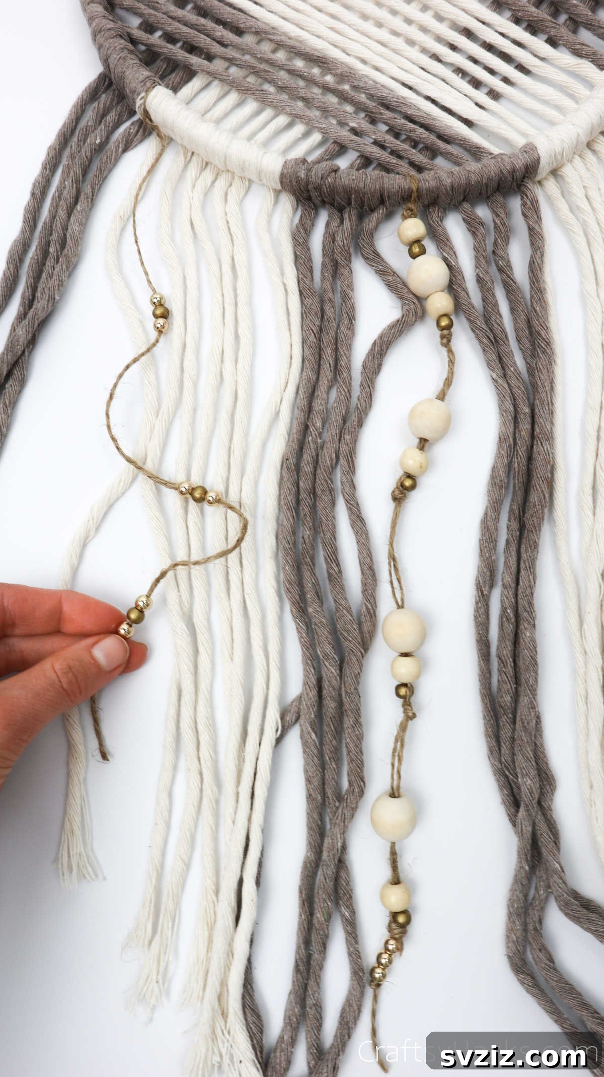 Holding beaded twine against the dreamcatcher, showing how the embellishments will hang.
