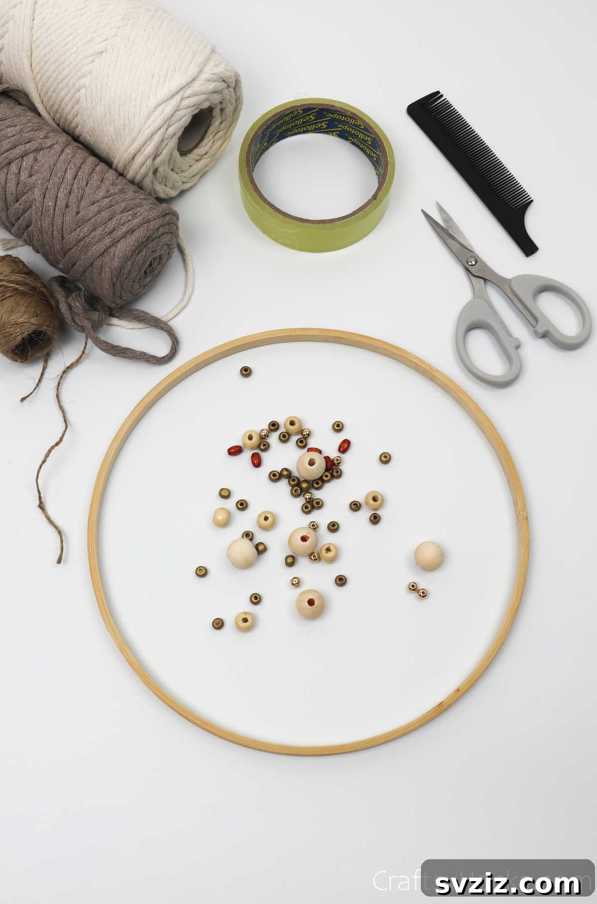 A flat lay showing all the craft supplies needed for a DIY dreamcatcher: cord, hoop, scissors, and beads.