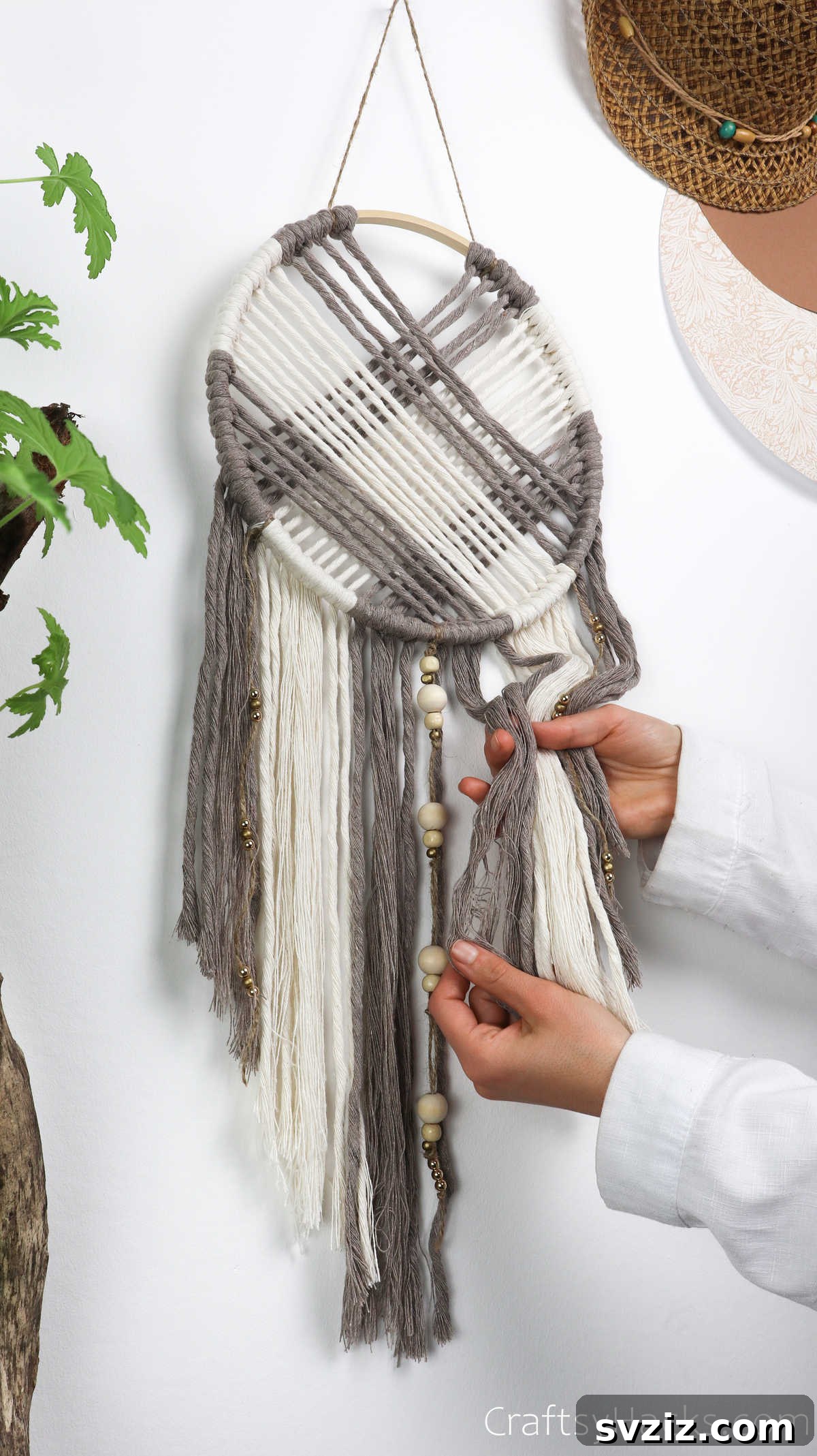 Holding the finished dreamcatcher, showing its beautiful texture and custom details, ready to hang.