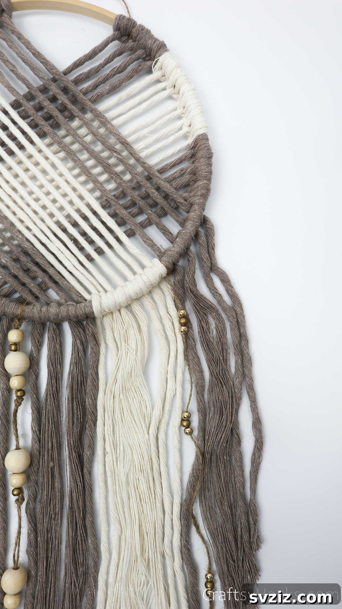 A close-up view of the intricate web and hanging elements of a completed DIY dreamcatcher.