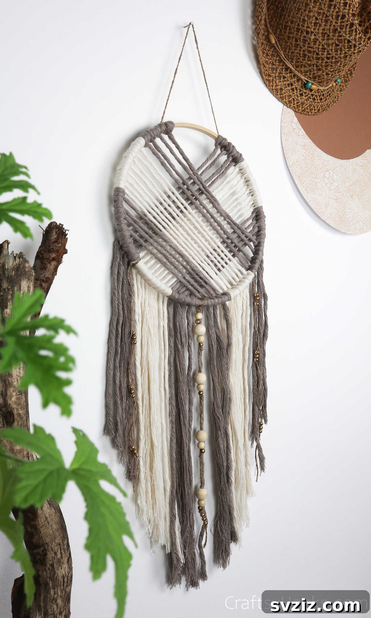 A beautifully completed dreamcatcher hanging on a textured wall, showcasing its intricate details.