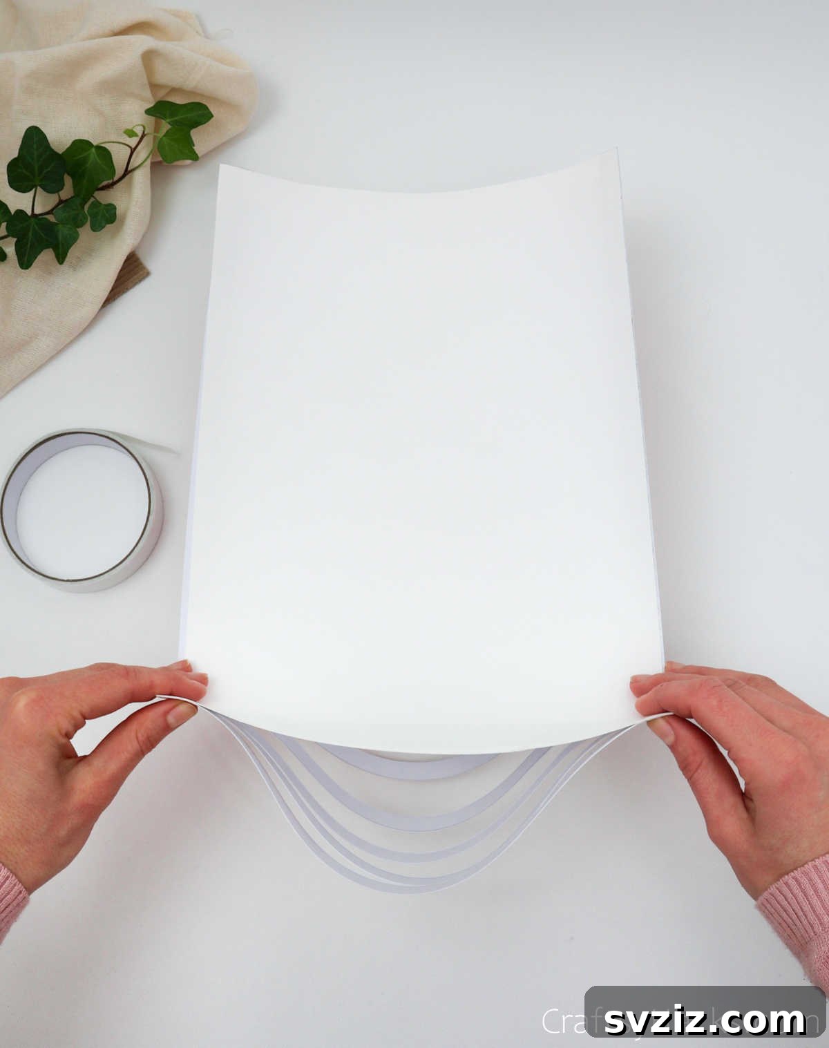 Craft Your Own Stunning Paper Lanterns 16 The taped side of the paper is gently folded over, bringing the ends together to form a cylindrical shape.